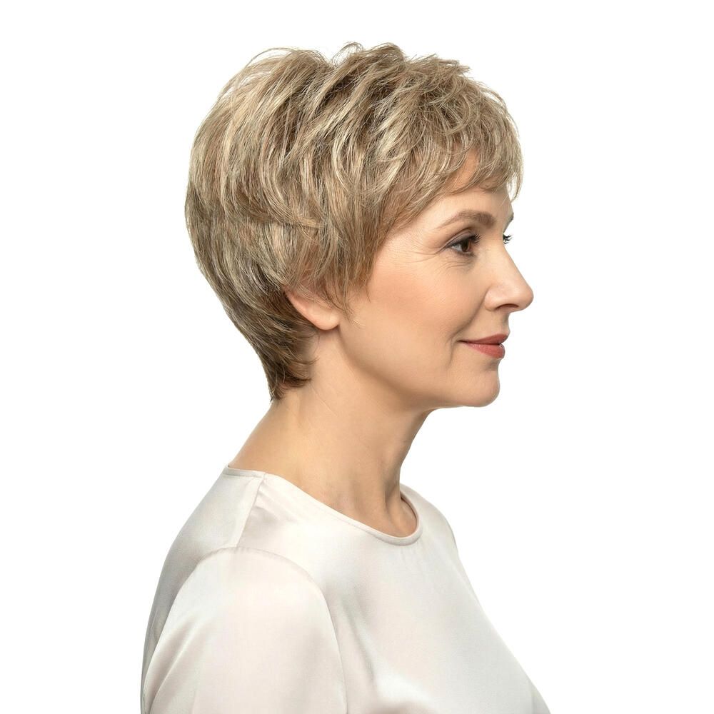 Kurzhaarperücke in Blondtönen. Seitenansicht einer Frau mit der Perücke. Hellbeige Oberteil.