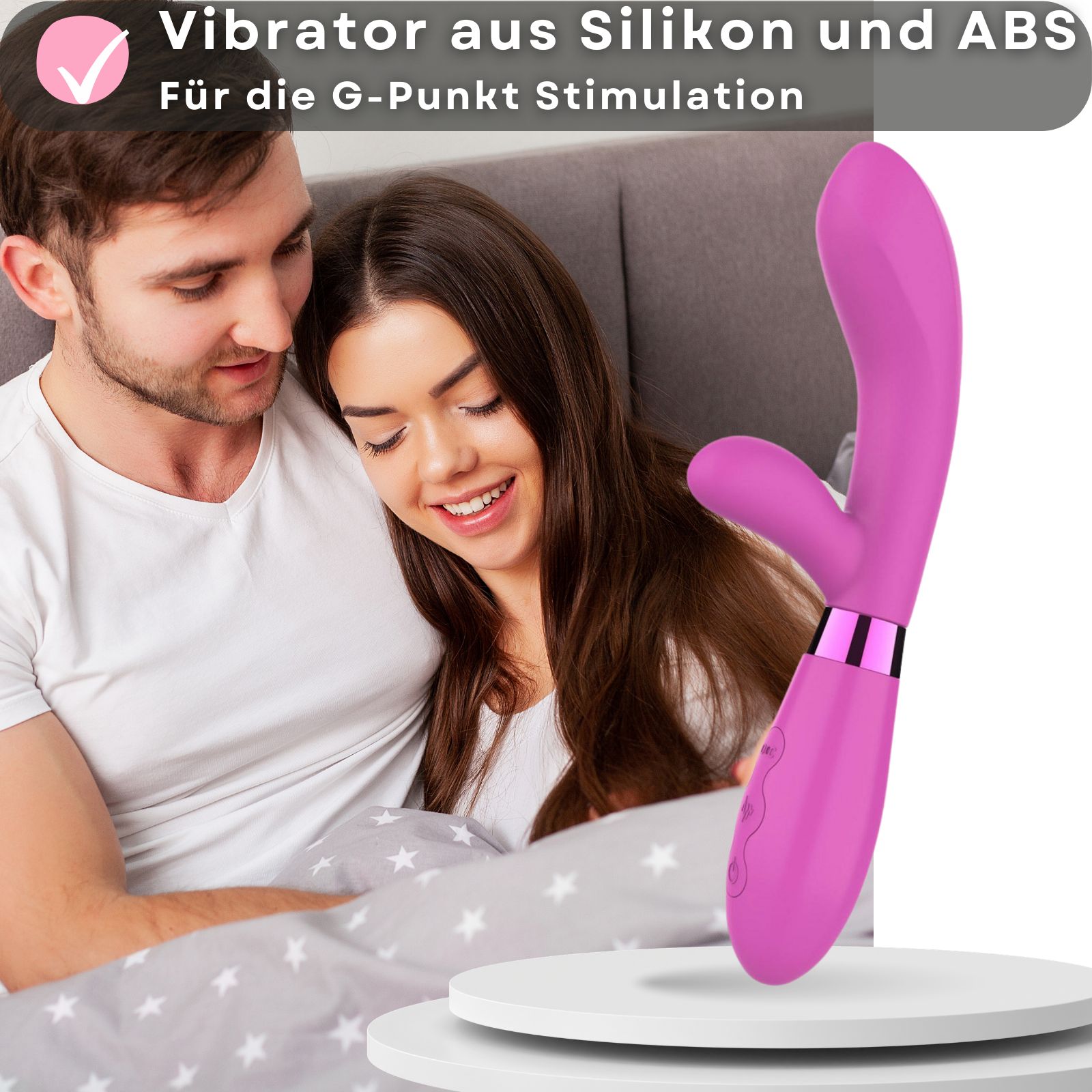 Rosa Vibrator aus Silikon und ABS. Für G-Punkt Stimulation. Paar im Hintergrund. Auf Podest platziert.