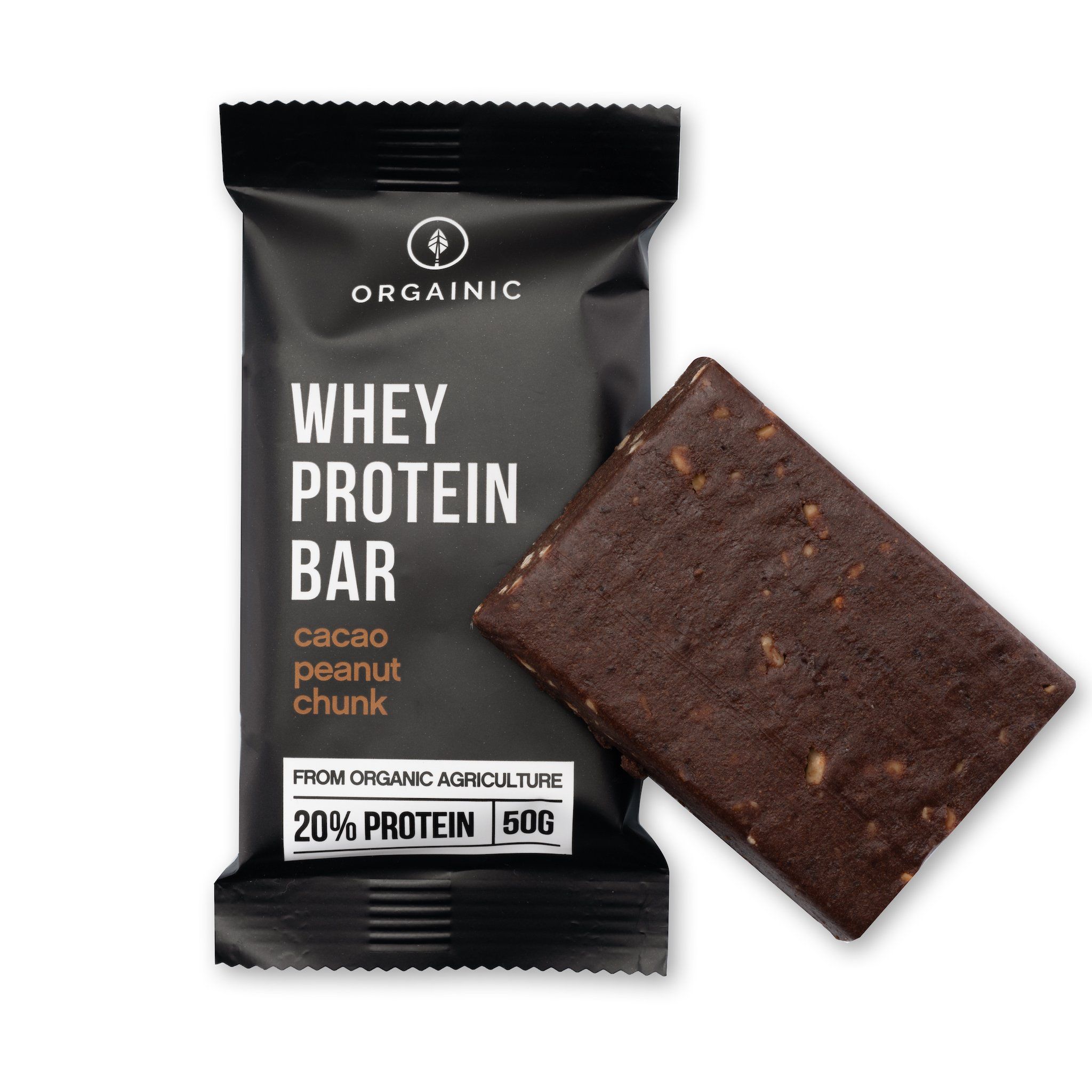 Schwarze Verpackung mit ORGAINIC-Logo und Text: Whey Protein Bar, Cacao Peanut Chunk. 20% Protein, 50g. Brauner Proteinriegel daneben.