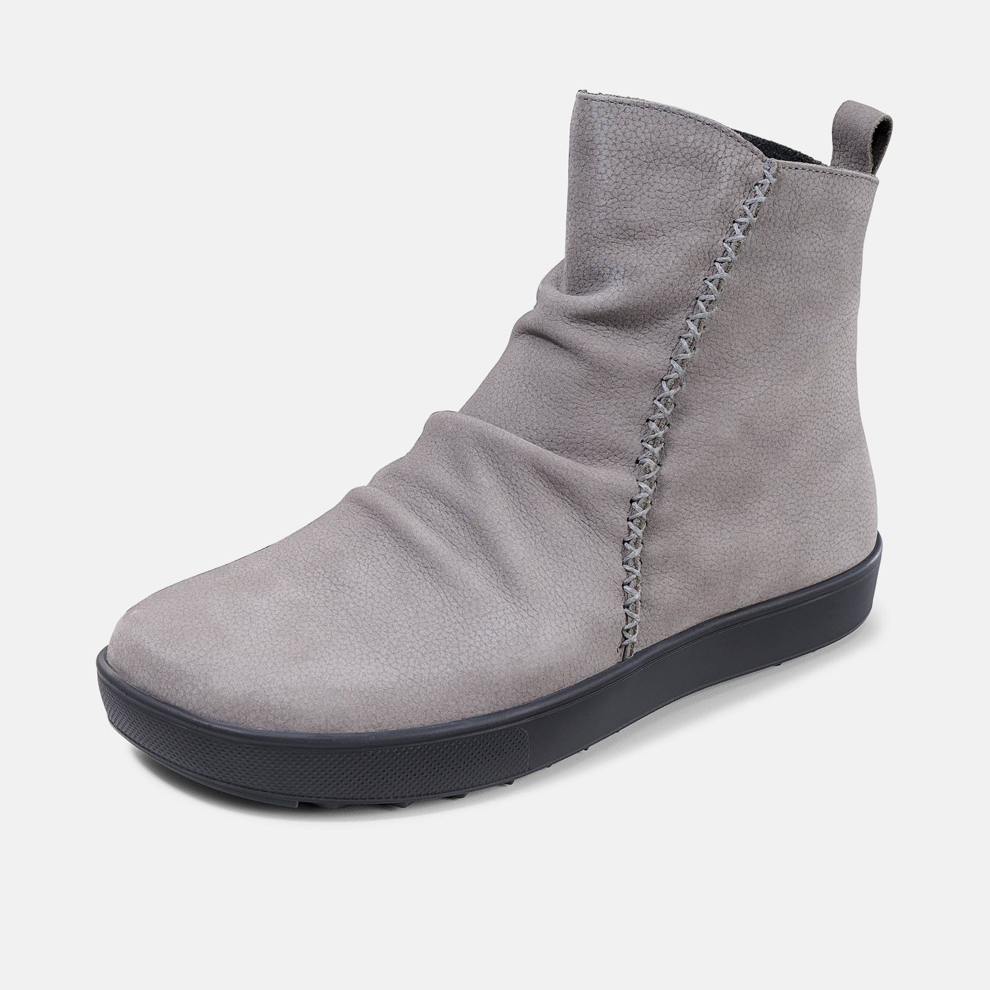 Graue Stiefelette mit schwarzer Sohle. Ziernähte am Schaft. Faltenwurf. Blick von der Seite.