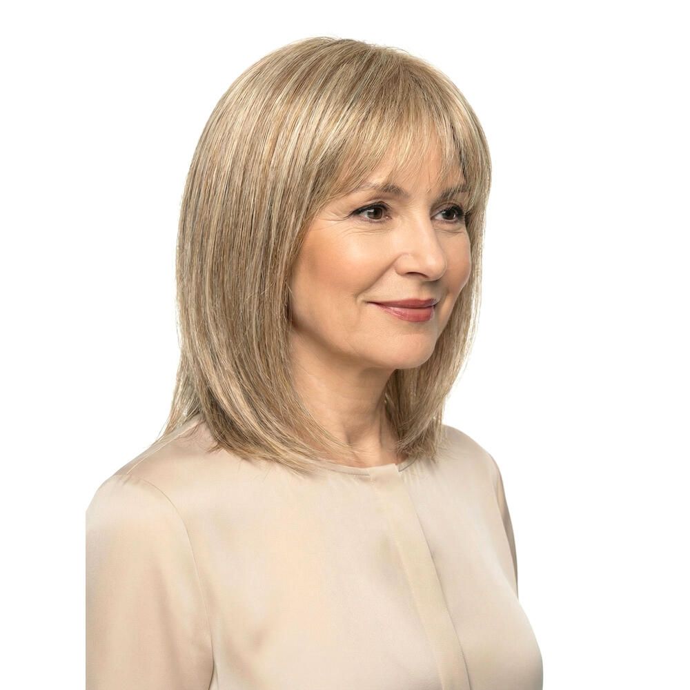 Blond gefärbte Perücke mit Pony. Mittellange, gestufte Haare. Frau mit hellem Oberteil. Frontale Ansicht.