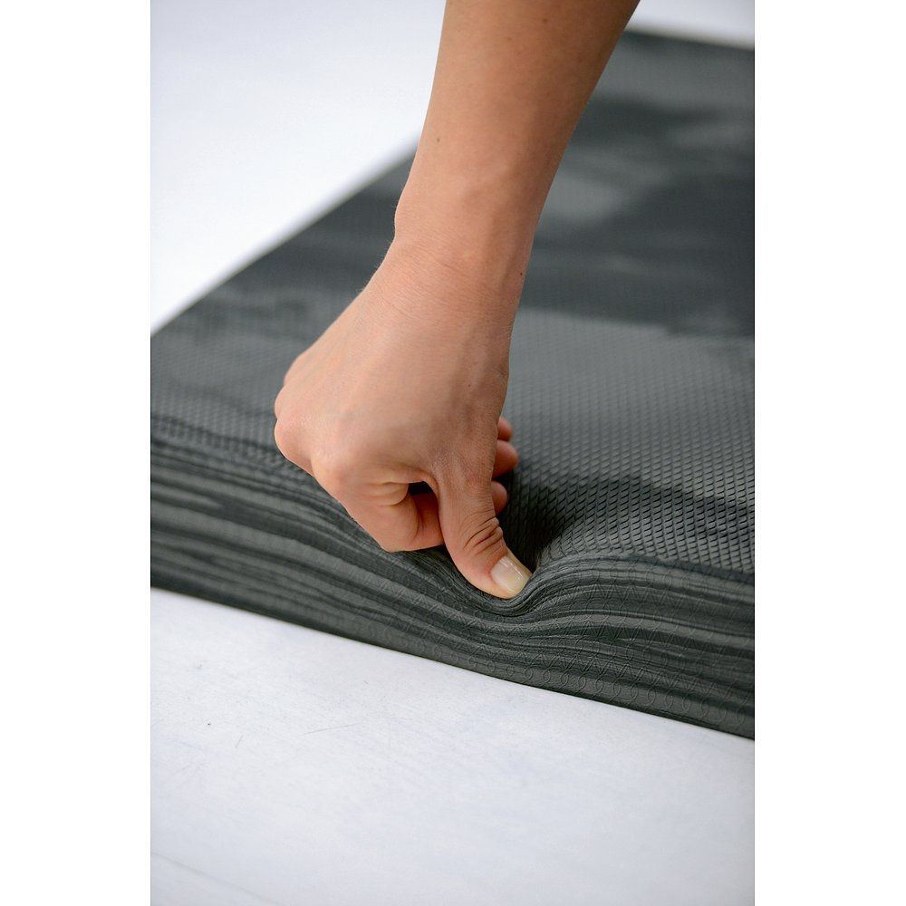 Graues Balance-Pad, rechteckig, mit einer Hand gedrückt. Oberflächenstruktur erkennbar.
