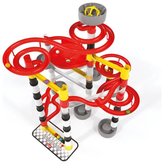 Quercetti Migoga Race, un set colorato di piste per biglie. Il percorso è composto da elementi in plastica rossa, gialla e bianca, assemblati per formare una struttura complessa. Supporti grigi e una zona di arrivo a scacchi completano il design. Diverse biglie colorate sono visibili sul percorso.