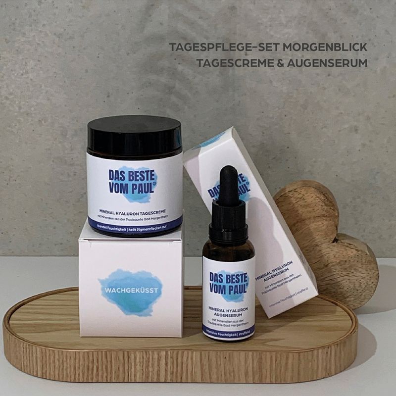 Set mit Tagescreme, Augenserum und Verpackungen. Aufschrift: DAS BESTE VOM PAUL®. Auf Holztablett.