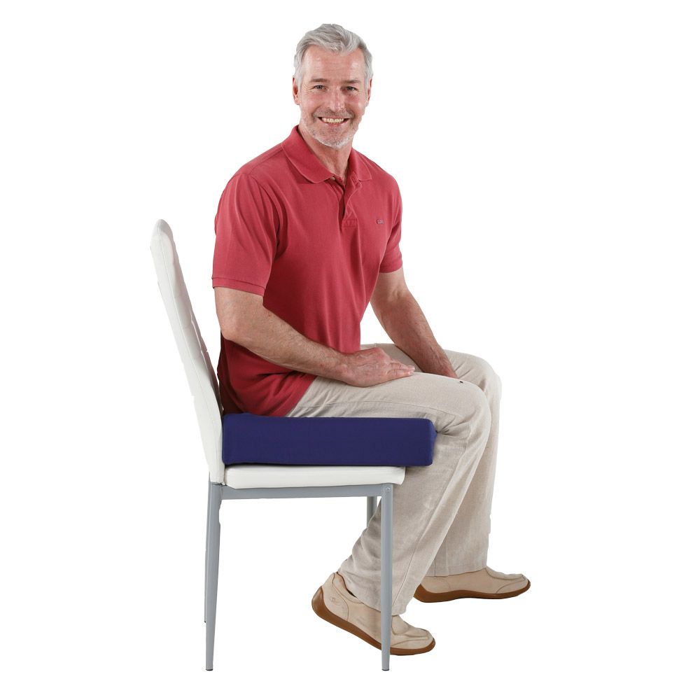 Ein Mann sitzt auf einem Stuhl mit einem blauen Sitzkissen.