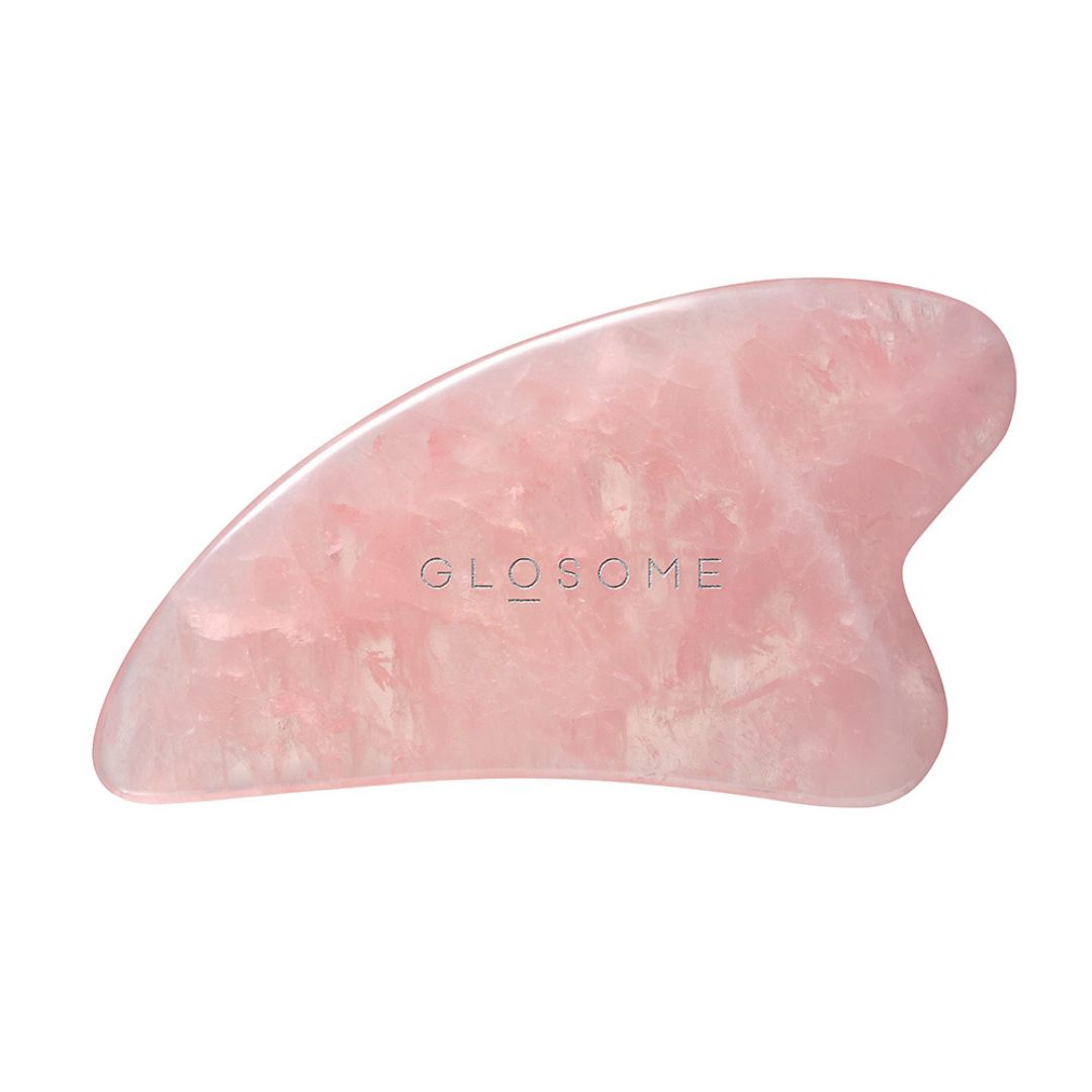 Rosafarbener Gua Sha aus Rosenquarz. Mit abgerundeten Kanten und dem Markennamen GLOSOME.