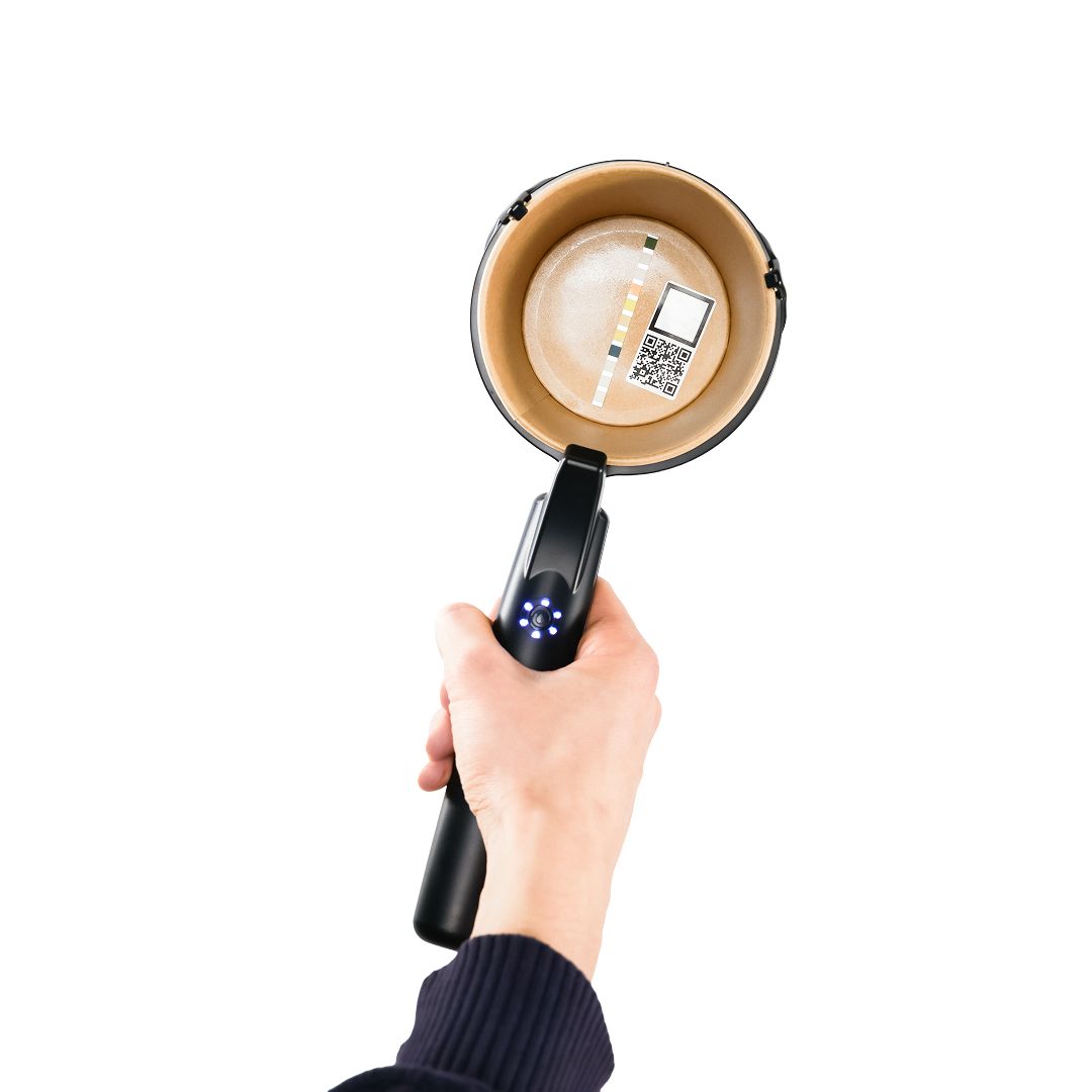 Hand hält schwarzen Griff mit Becher. Becher mit QR-Code. Auf weißem Hintergrund.