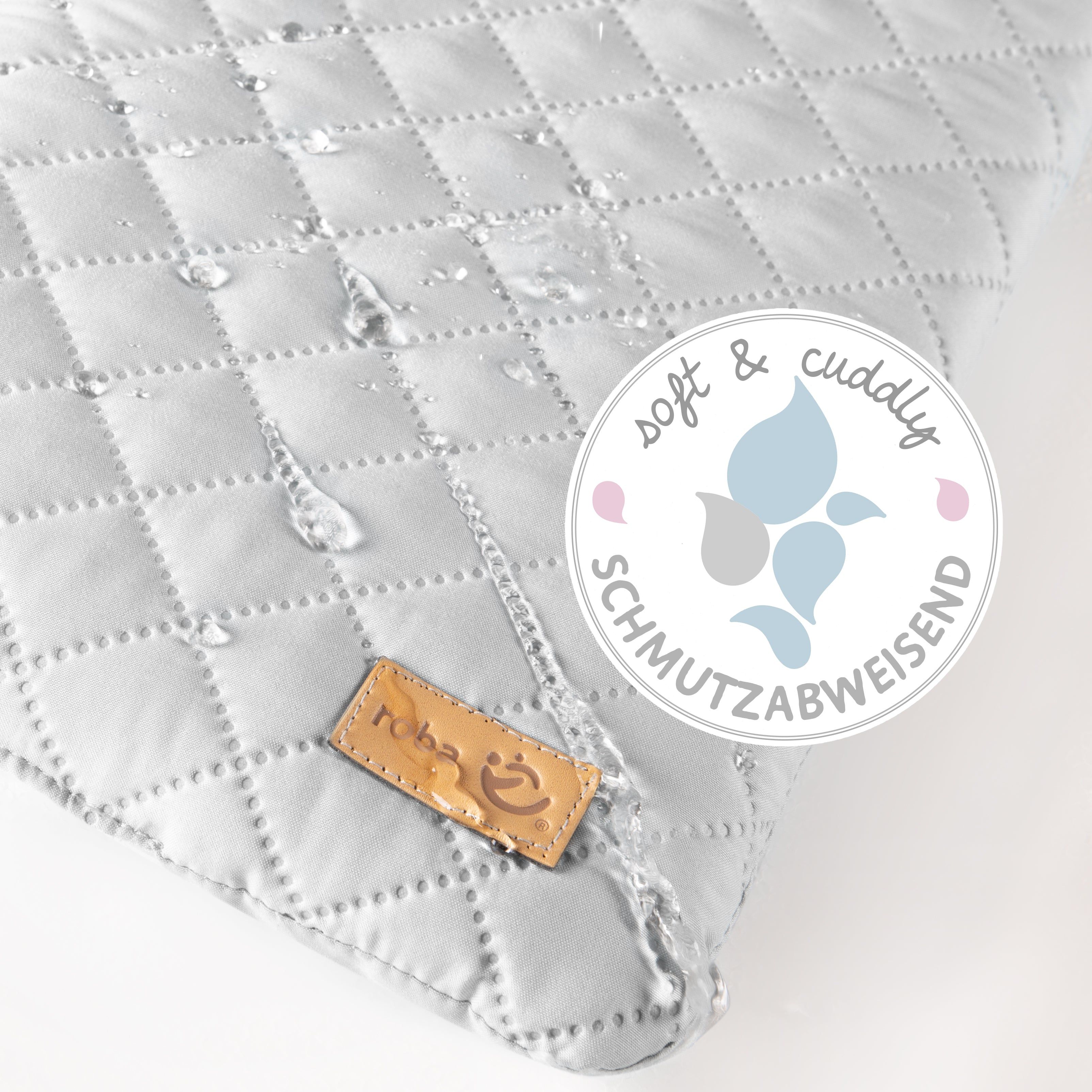 Graue Wickelauflage mit gesteppter Oberfläche. Wasserabweisend. Braunes Label mit Logo. Text: soft & cuddly, schmutzabweisend.