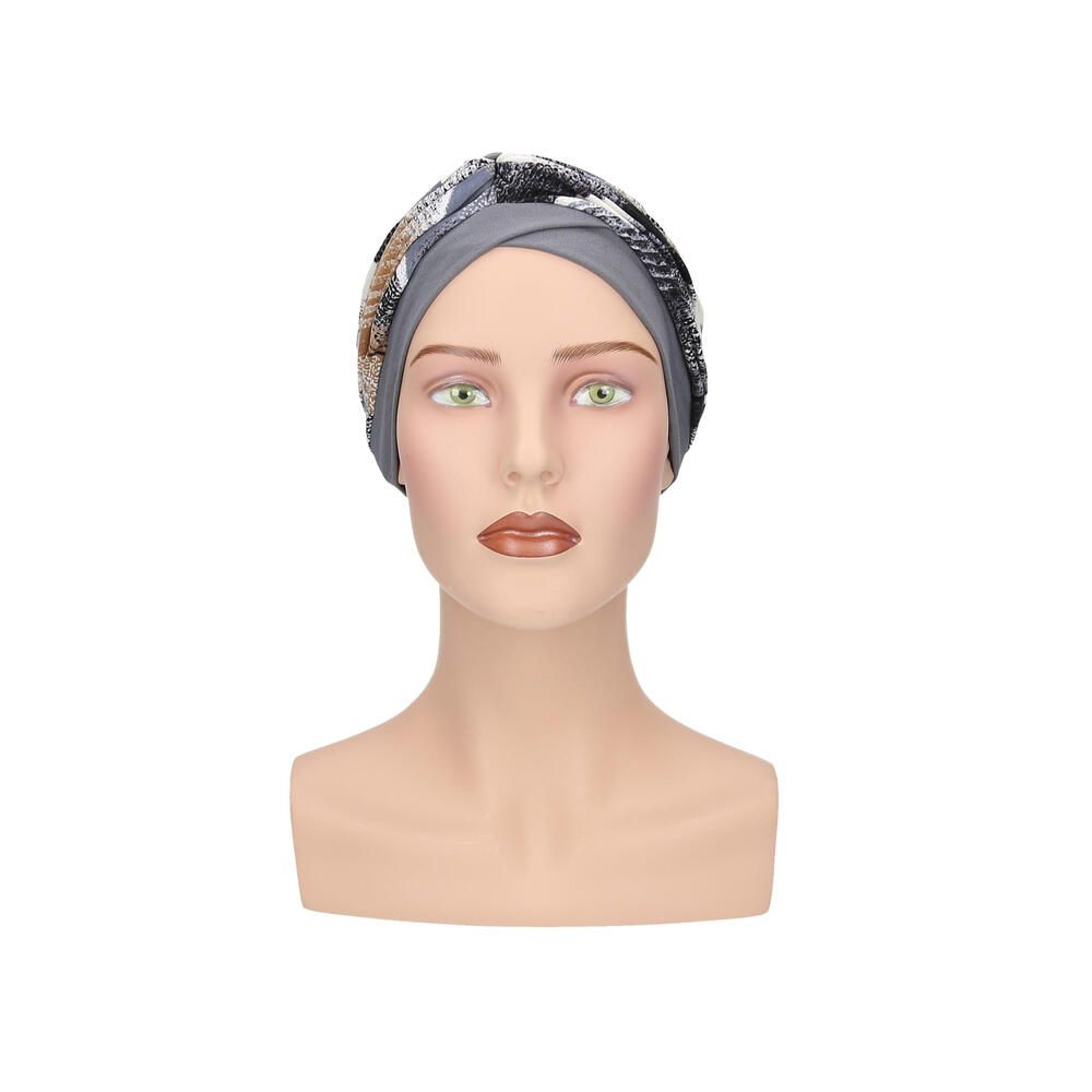 Grauer Turban mit Muster auf einer Schaufensterpuppe. Vorderansicht.