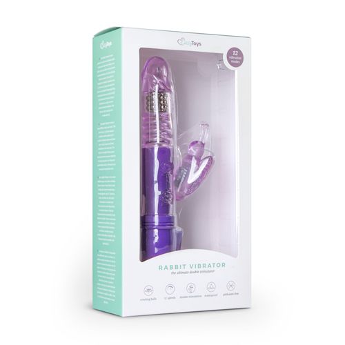 Violett Rabbit Vibrator in Verpackung. Der Vibrator hat eine längliche Form mit einem gebogenen Teil und einem Hasenohren-Aufsatz.