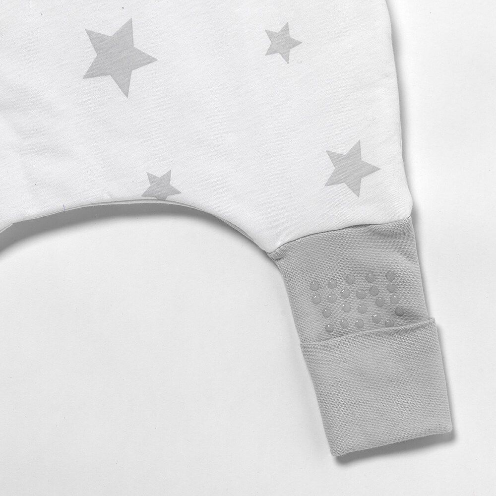 Detailansicht des Fußbündchens eines Baby-Schlafsacks mit grauen Sternen. Anti-Rutsch-Noppen.
