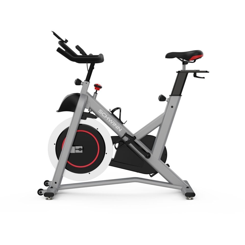 Graues Indoor-Cycle. Sichtbar: Sattel, Lenker, Schwungrad. Marke: Schwinn. Roter Akzent am Schwungrad.