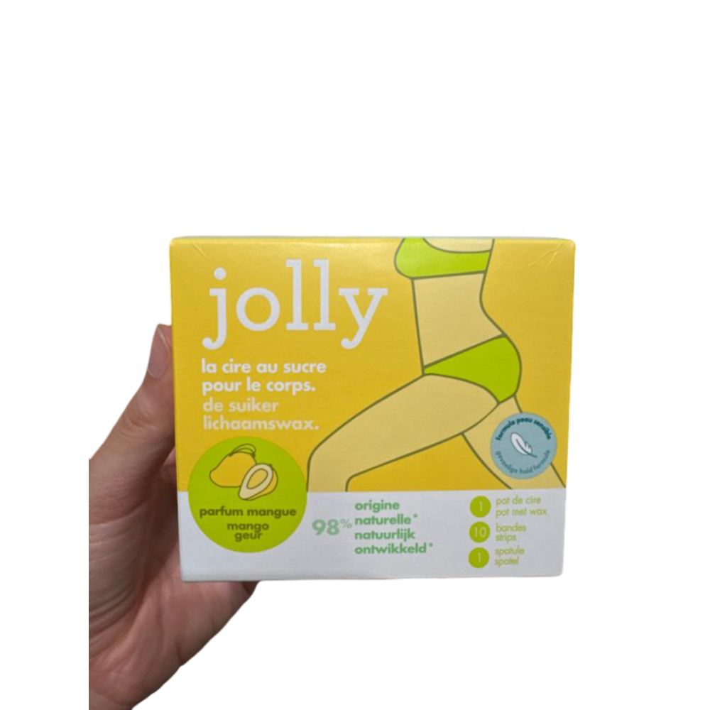 Gelbe Produktverpackung "Jolly" mit Illustration. Enthält Wachs, Streifen und Spatel. Mango-Duft. Hand hält die Verpackung.