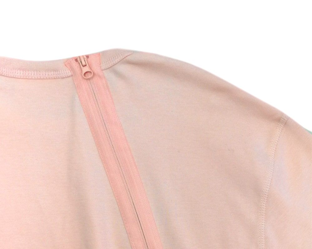 Detailansicht des apricotfarbenen Pflegeoveralls. Reißverschluss am Kragen.