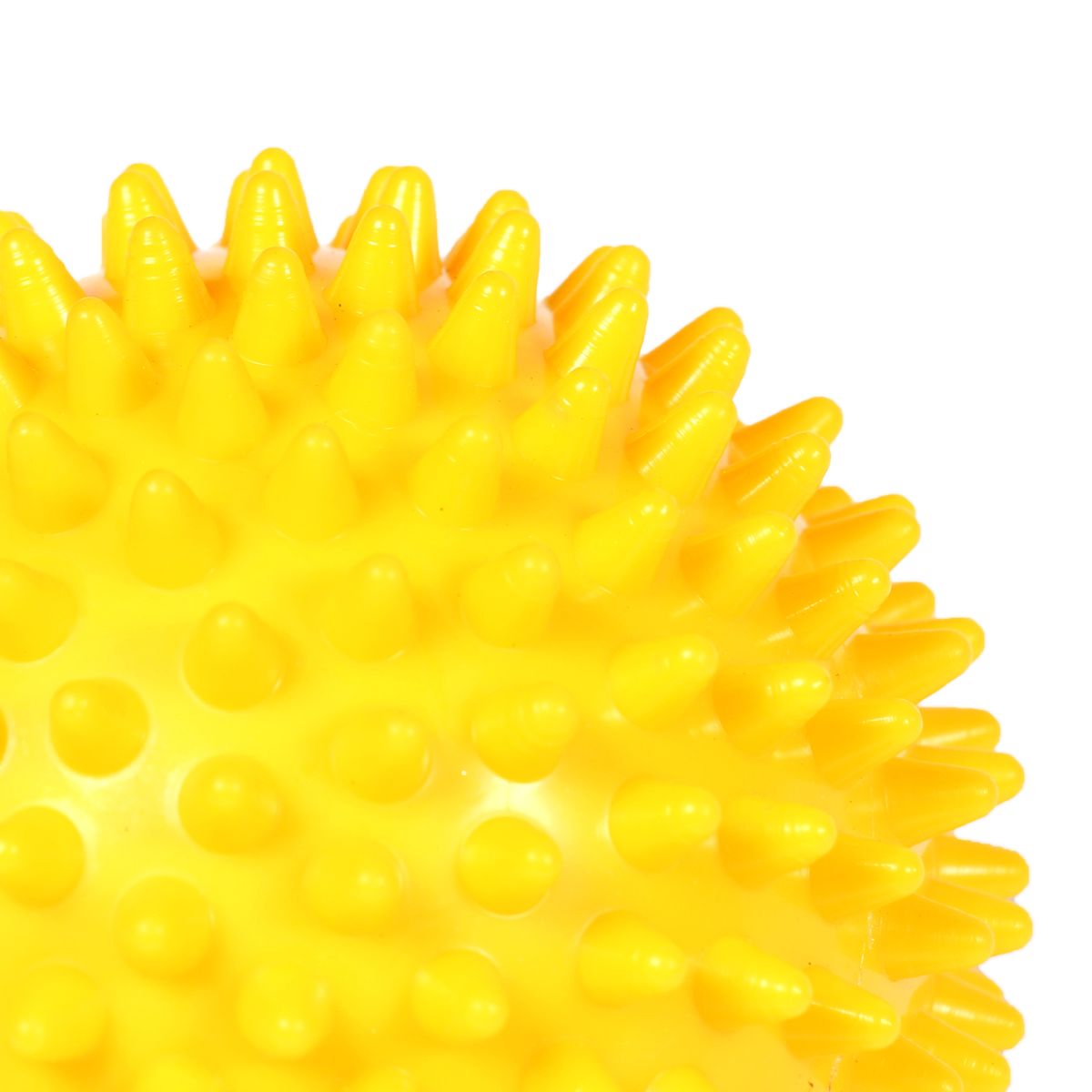Gelber Massageball mit Noppen. Detailansicht der Oberfläche mit konischen Erhebungen. Ausschnitt, isoliert auf weißem Hintergrund.