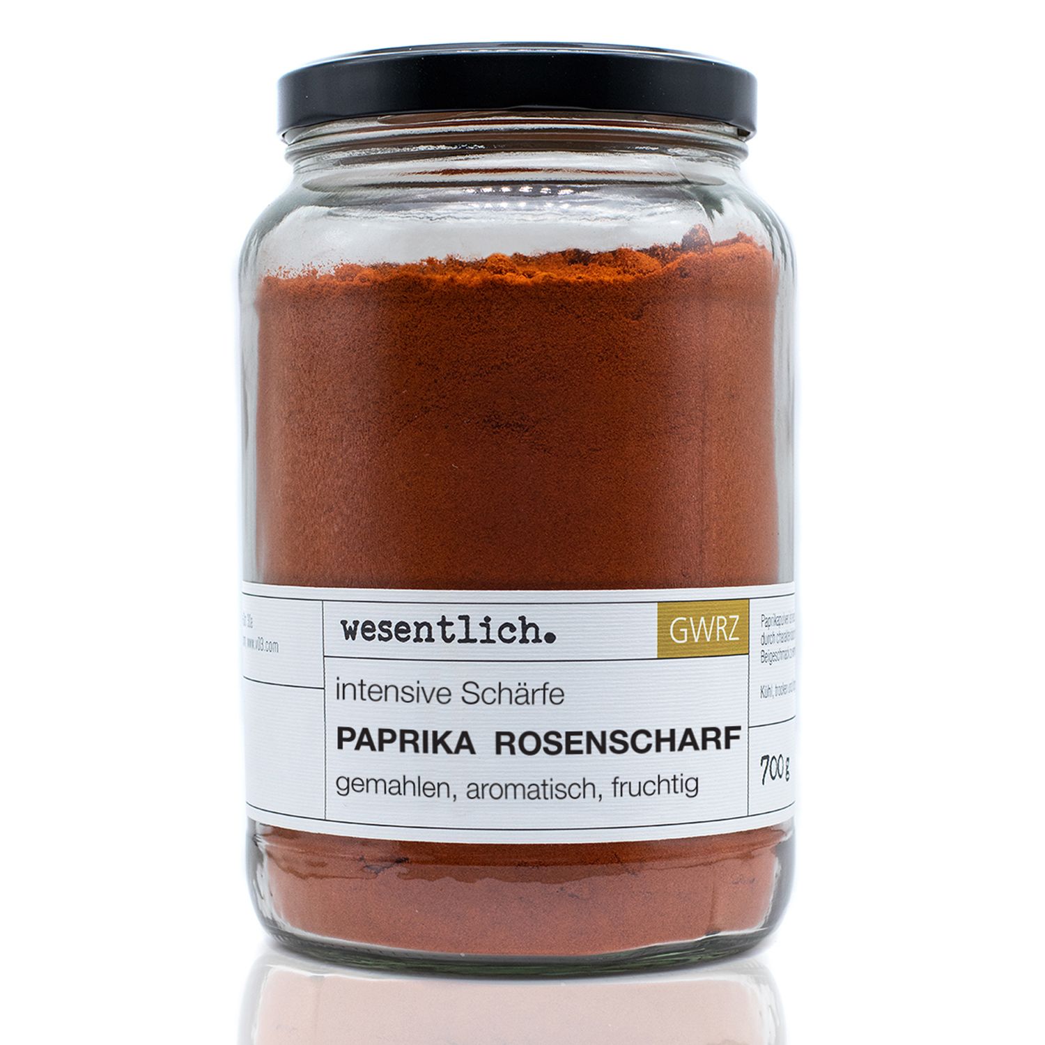 Glas mit Paprikapulver rosenscharf von wesentlich. Schwarzer Deckel. Etikett mit Produktinformationen.