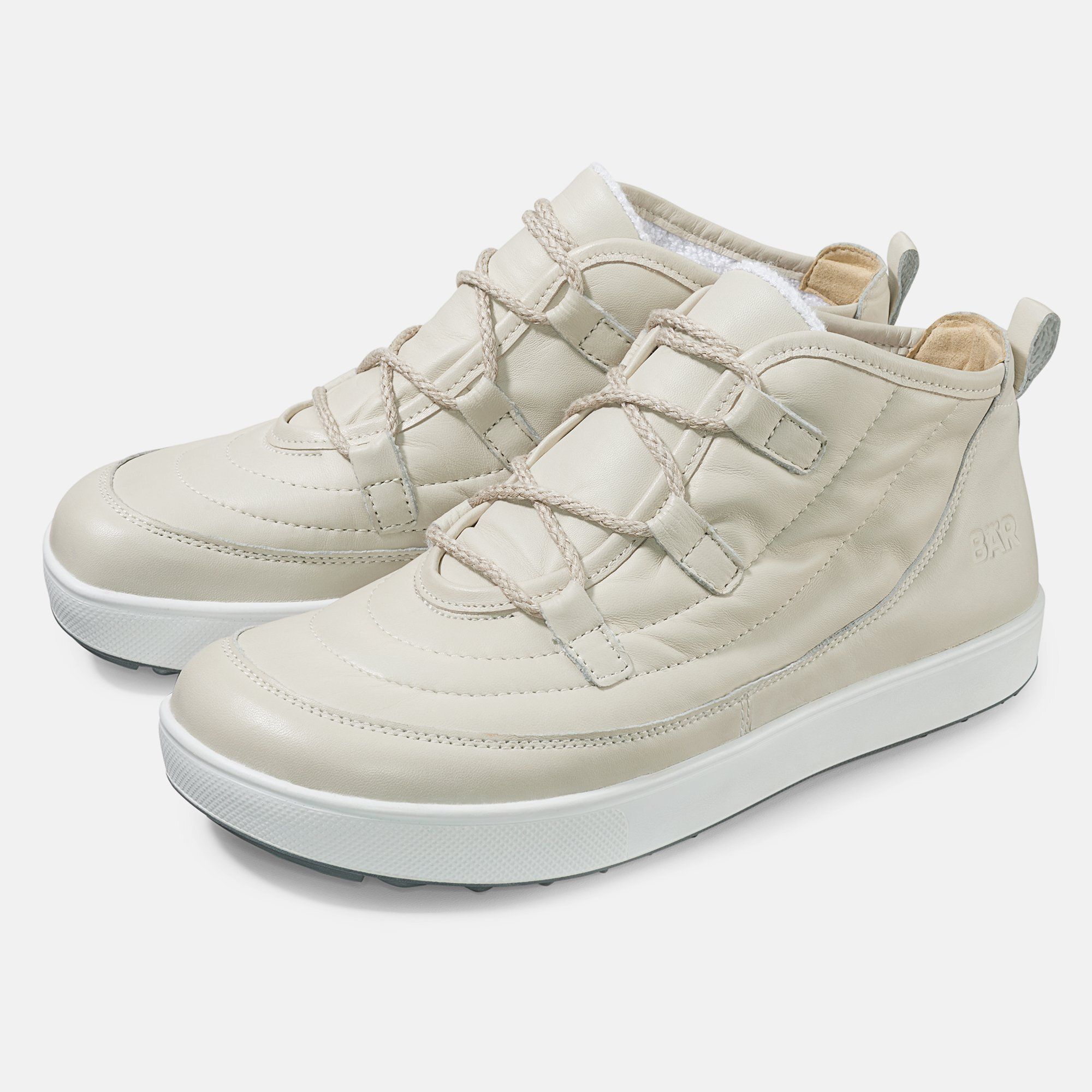 Beige Stiefeletten mit Schnürung und weißer Sohle. Gepolstertes Obermaterial, seitliche Lasche. BÄR-Logo.