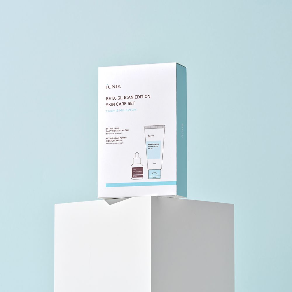 Produktverpackung auf einem weißen Podest. Die Box zeigt eine Abbildung von Creme und Serum. Marke iUNIK, Produktname Beta-Glucan Edition.