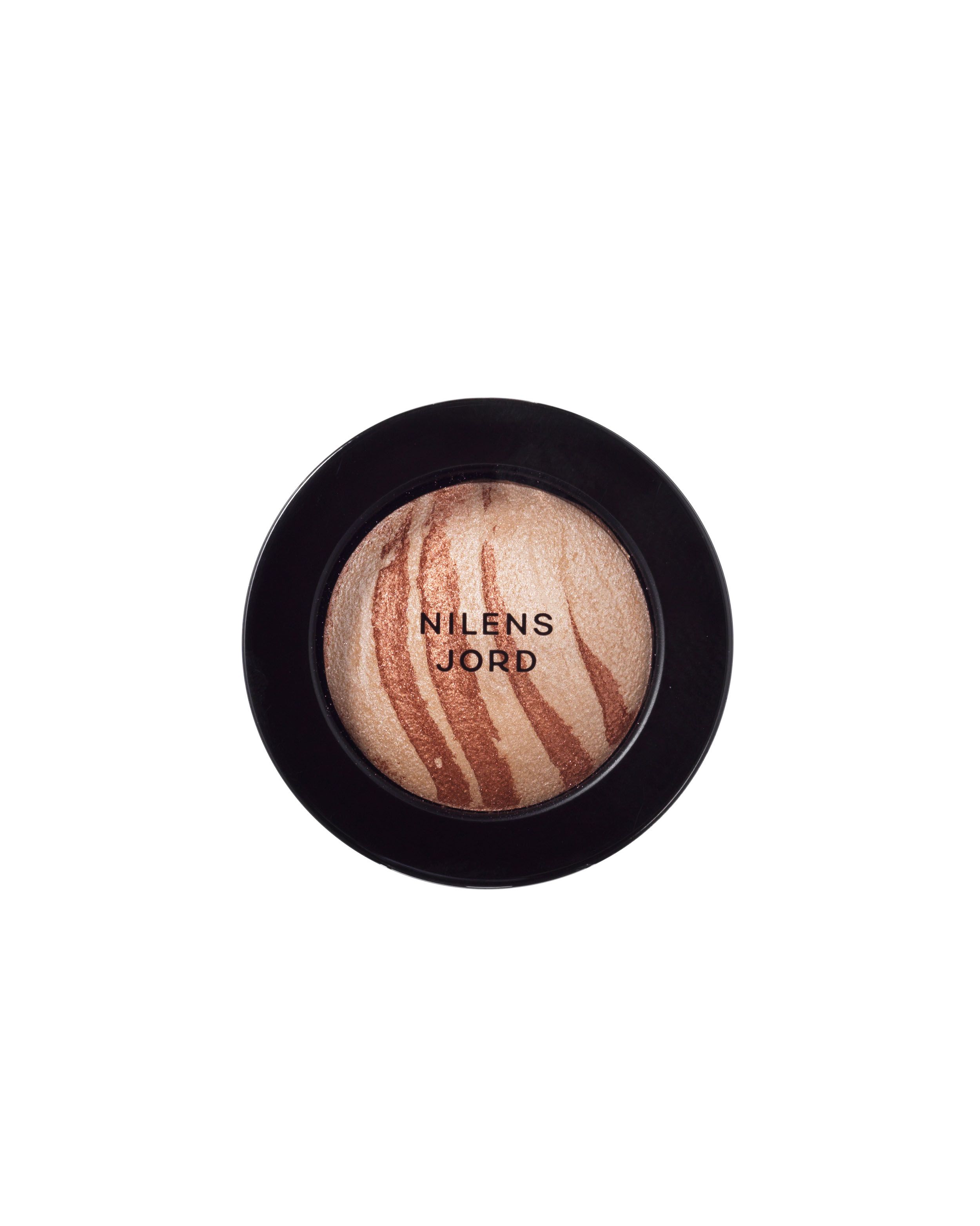 Nilens Jord Baked Mineral Eyeshadow in einem schwarzen Tiegel mit offenem Deckel. Marmoriertes Muster in Gold- und Beigetönen.