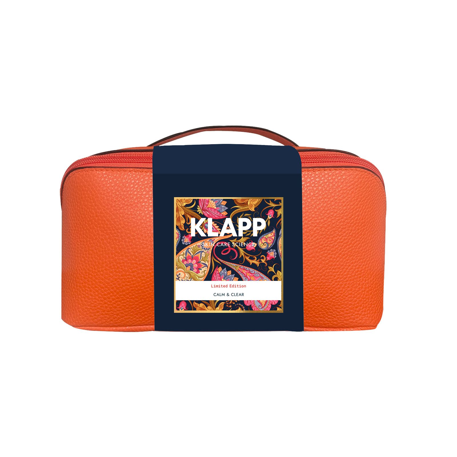 Orangene Kosmetiktasche mit Griff und Aufschrift: KLAPP, Calm & Clear. Auf der Tasche ein Etikett mit floralem Muster.