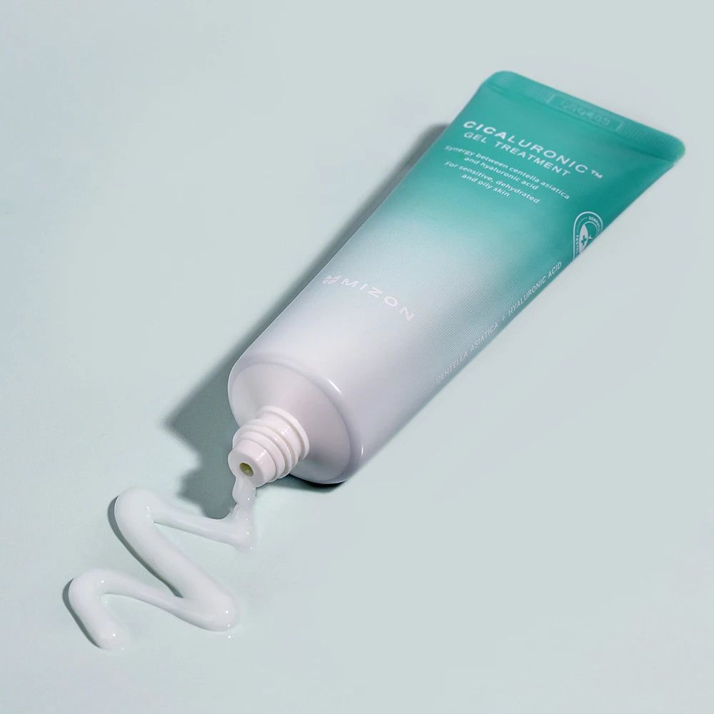 Grüne und weiße Tube, aus der Produkt austritt. Aufschrift: Cicaluronic Gel Treatment. Marke: Mizon. Produkt auf blauem Untergrund.