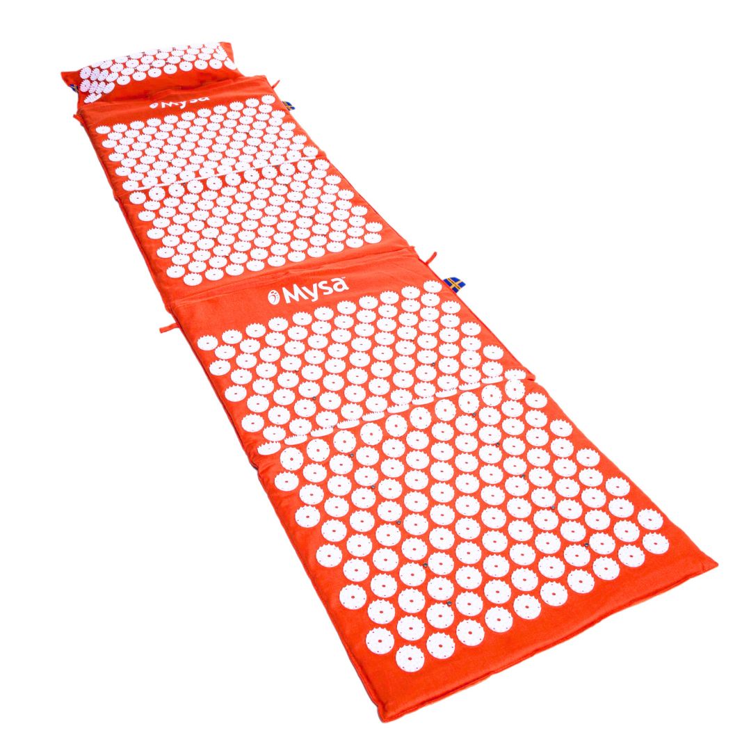Orangefarbene Akupressurmatte mit weißen Spitzen. Das Produkt ist sichtbar. Das Mysa-Logo ist sichtbar.