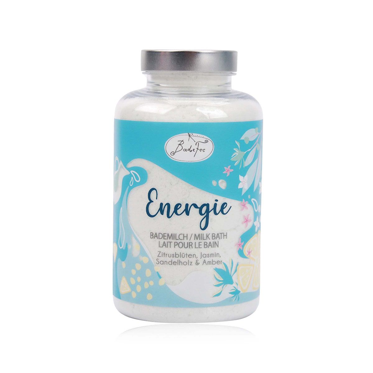 Zylindrische Glasflasche mit Badefee Milchbad Energie. Türkis-weißes Etikett mit Produktnamen und Inhaltsstoffen. Silberner Deckel.