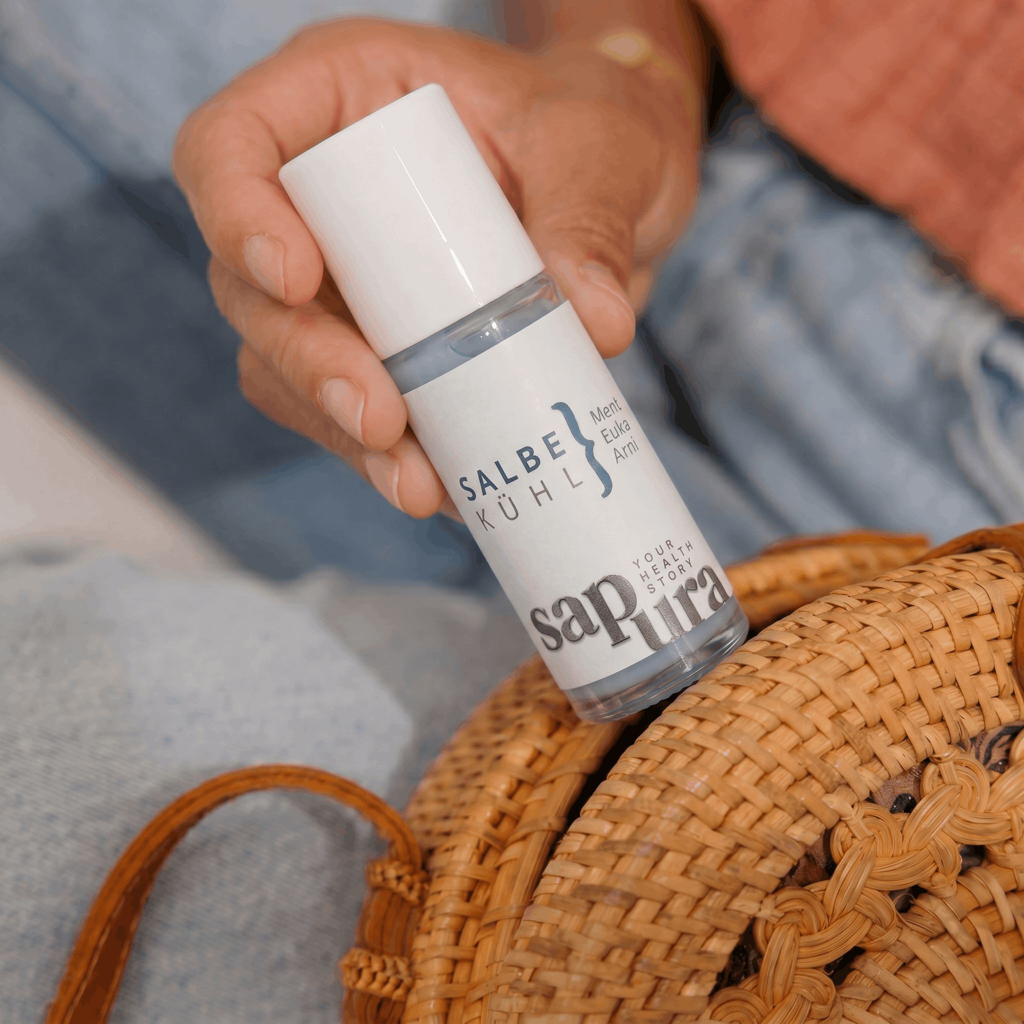 Kühlsalbe Roll-On in einer Handtasche aus Bast.