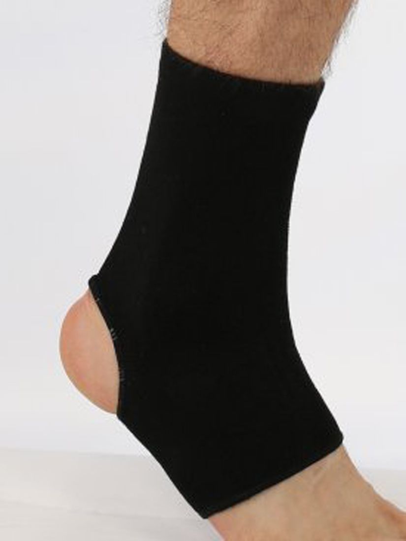 Schwarze Sprunggelenkbandage am Bein. Nylonmaterial. Offene Ferse.
