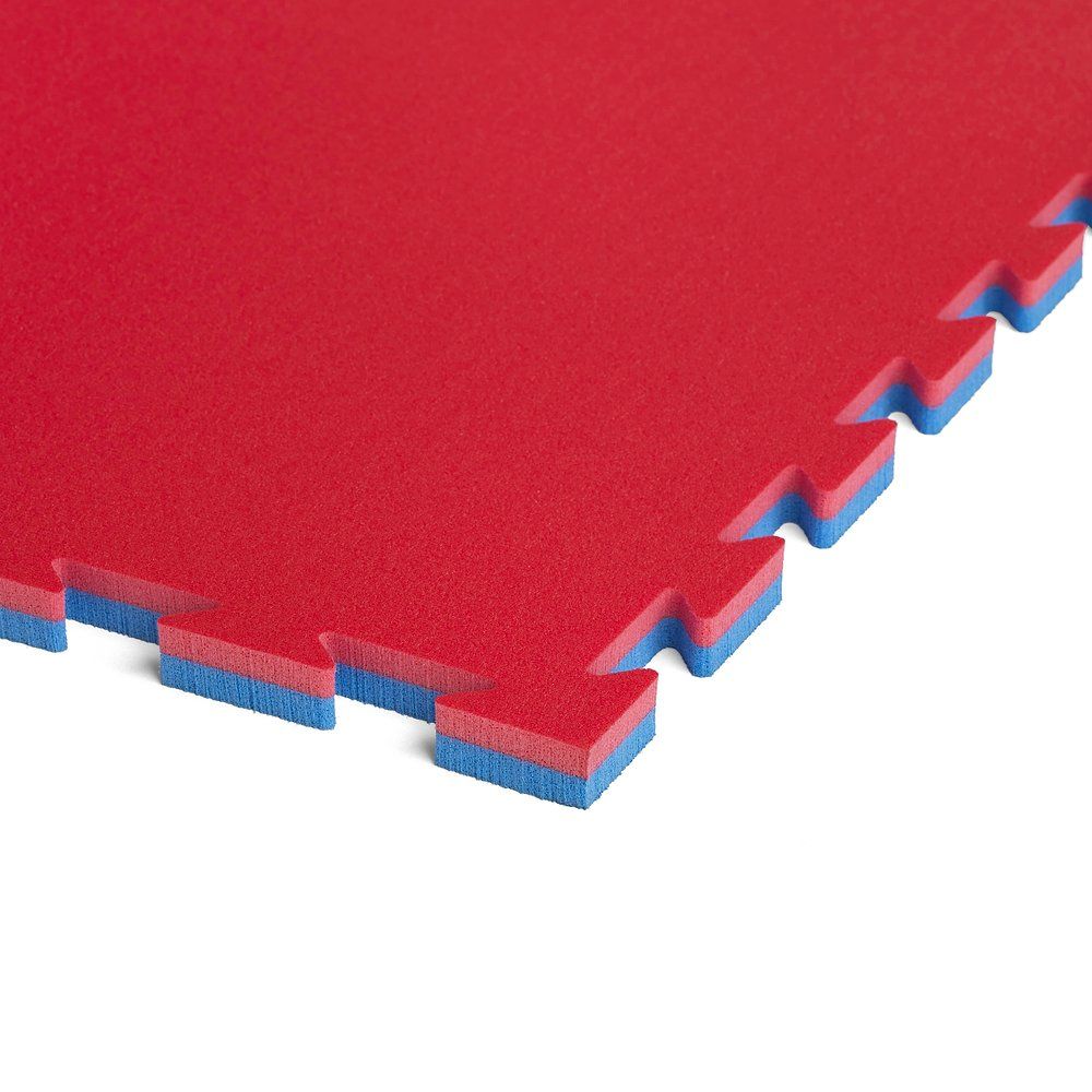 Nahaufnahme einer roten und blauen Puzzle-Fitnessmatte. Ineinandergreifende Kanten sichtbar.
