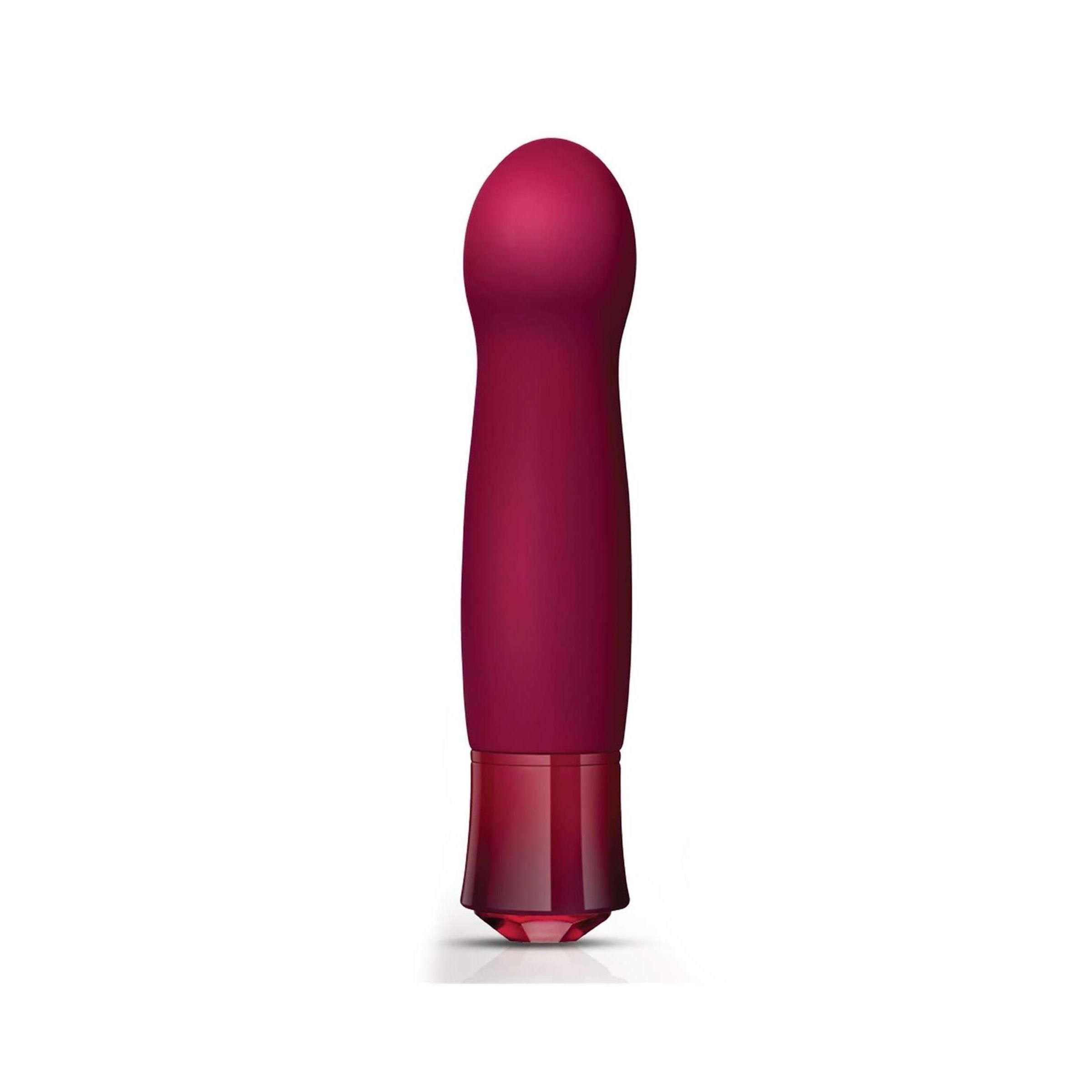 Ein aufrechter Vibrator mit runder Spitze und Kristallfuß. Er steht auf einer weißen Oberfläche.