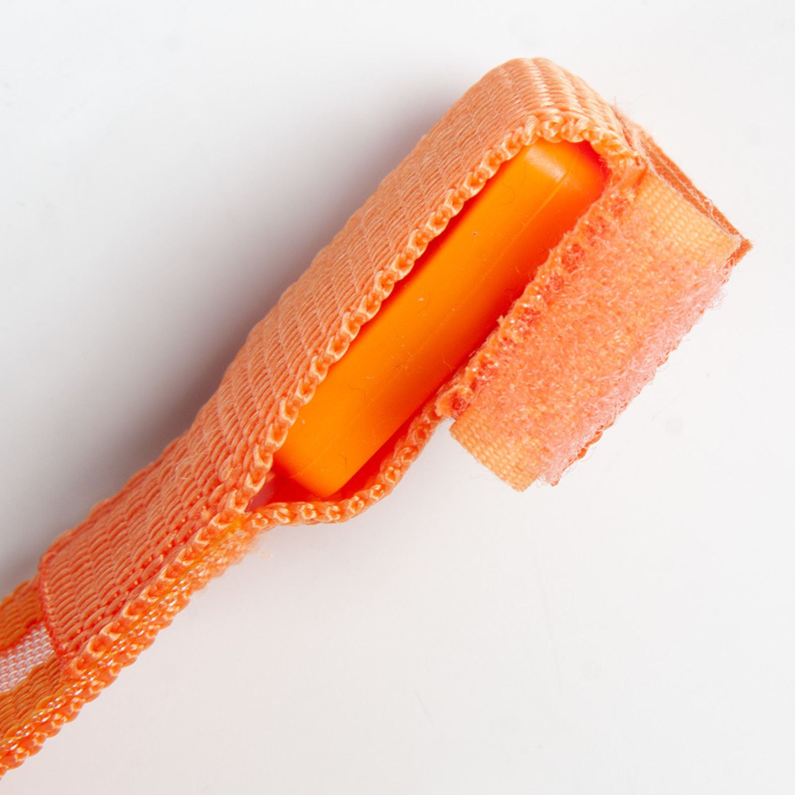 Nahaufnahme des Klettverschlusses und der Schlaufe des reflektierenden Bandes. Orangefarbenes Material.