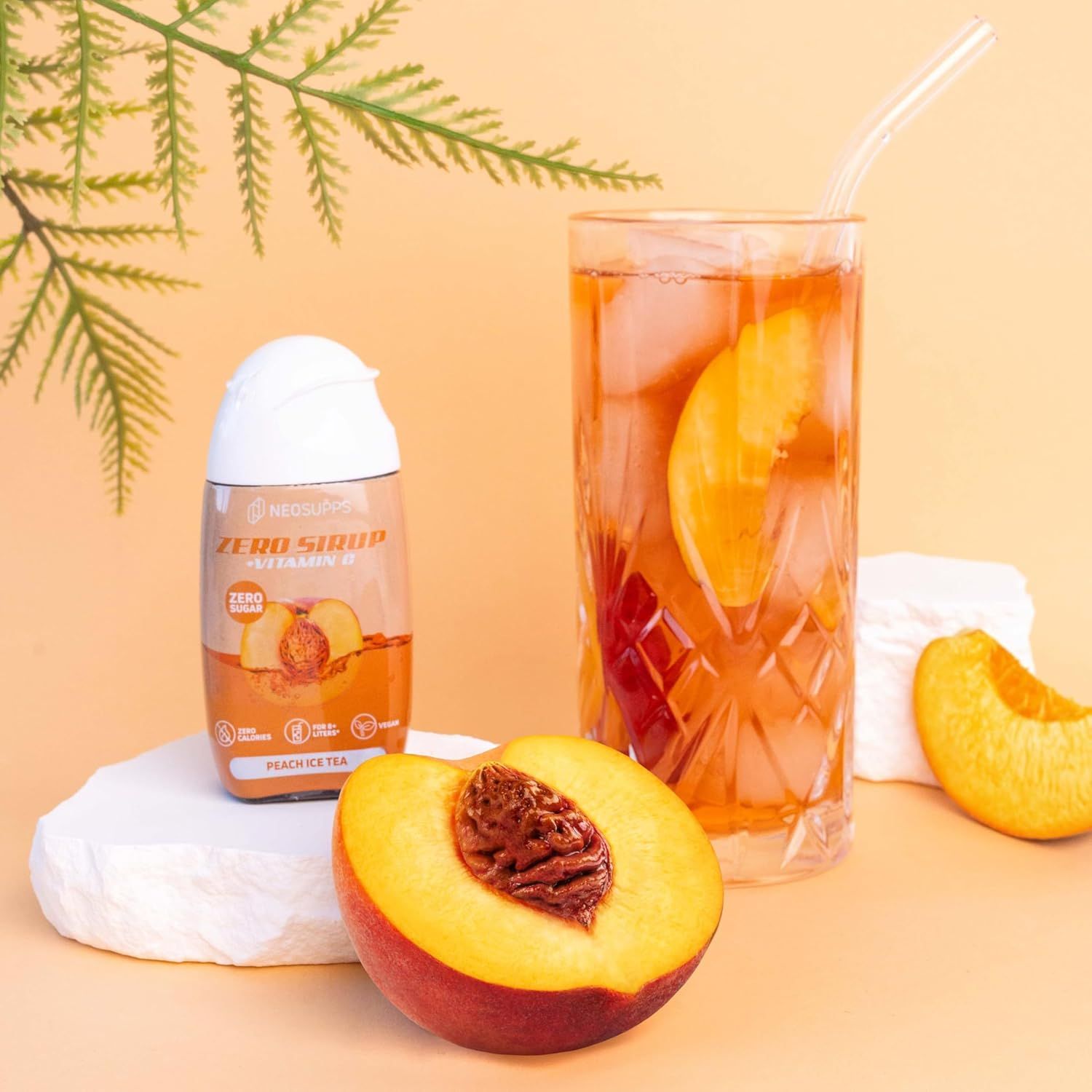 Glas Eistee mit Pfirsich, Flasche Sirup und halber Pfirsich. Auf der Flasche steht "Zero Sirup".