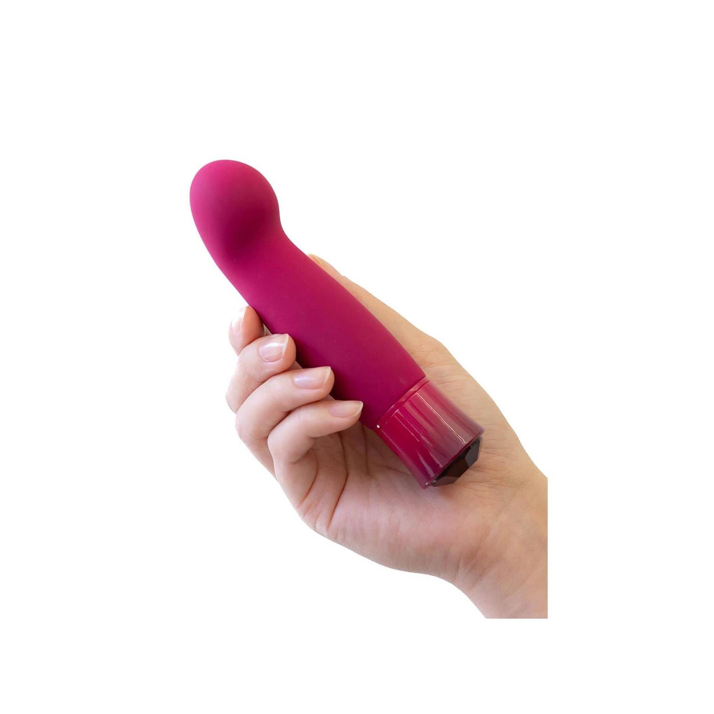 Ein Vibrator in einer Hand gehalten. Er hat eine gebogene Form, eine runde Spitze und einen Kristallfuß.