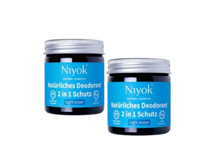 Zwei Gläser Niyok 2-in-1 Deocreme, Naturkosmetik, vegan. Die Gläser haben einen schwarzen Körper, einen silbernen Deckel und ein blaues Etikett mit weißer Schrift. Auf dem Etikett steht "Niyok", "Natürliches Deodorant", "2 in 1 Schutz" und "Light ocean".