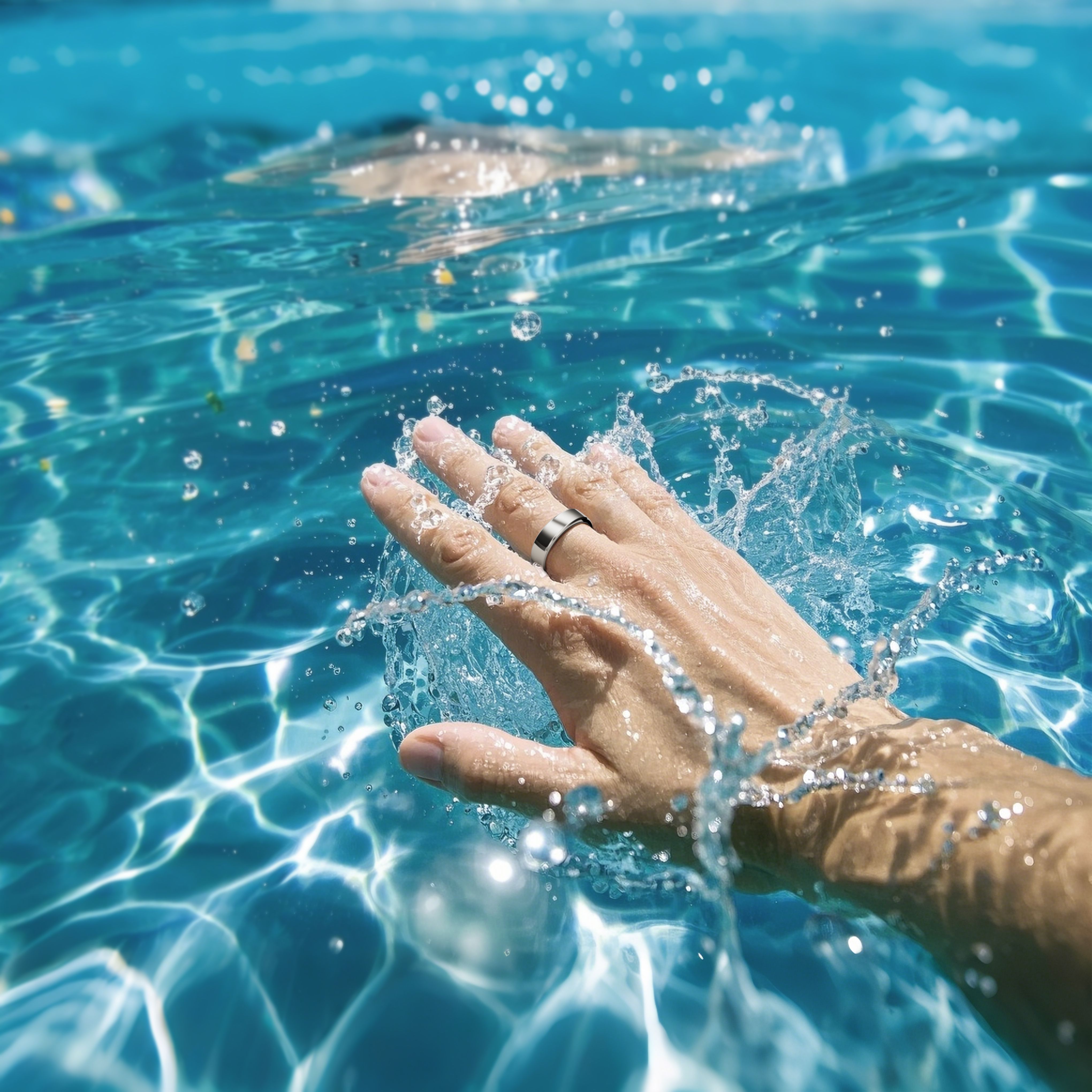 Hand im Wasser, Ring am Finger. Wasser spritzt. Blauer Hintergrund.