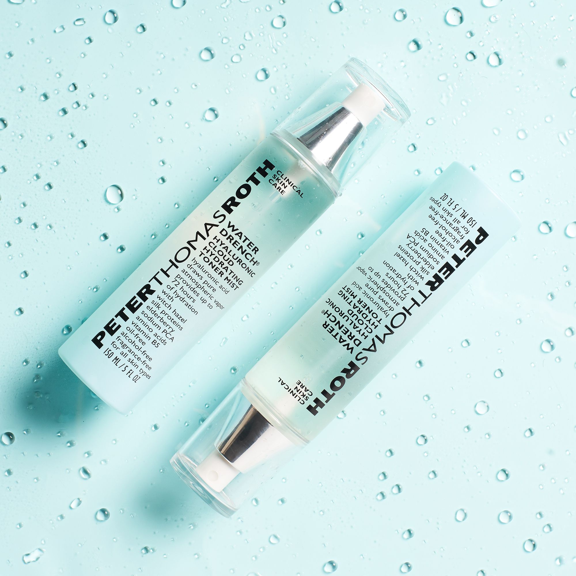 Zwei Peter Thomas Roth Water Drench Hydrating Toner Mist Flaschen. Auf blauem Hintergrund mit Wassertropfen.