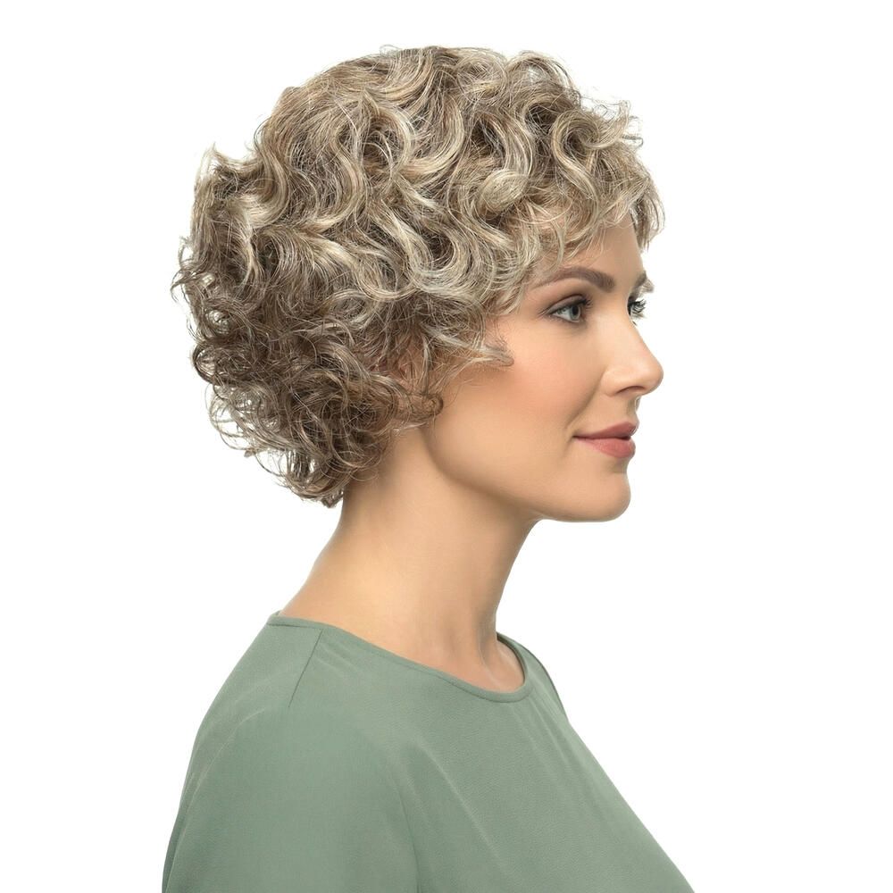 Perücke mit lockigem, blondiertem Haar. Die Frau trägt ein grünes Oberteil. Seitenansicht.