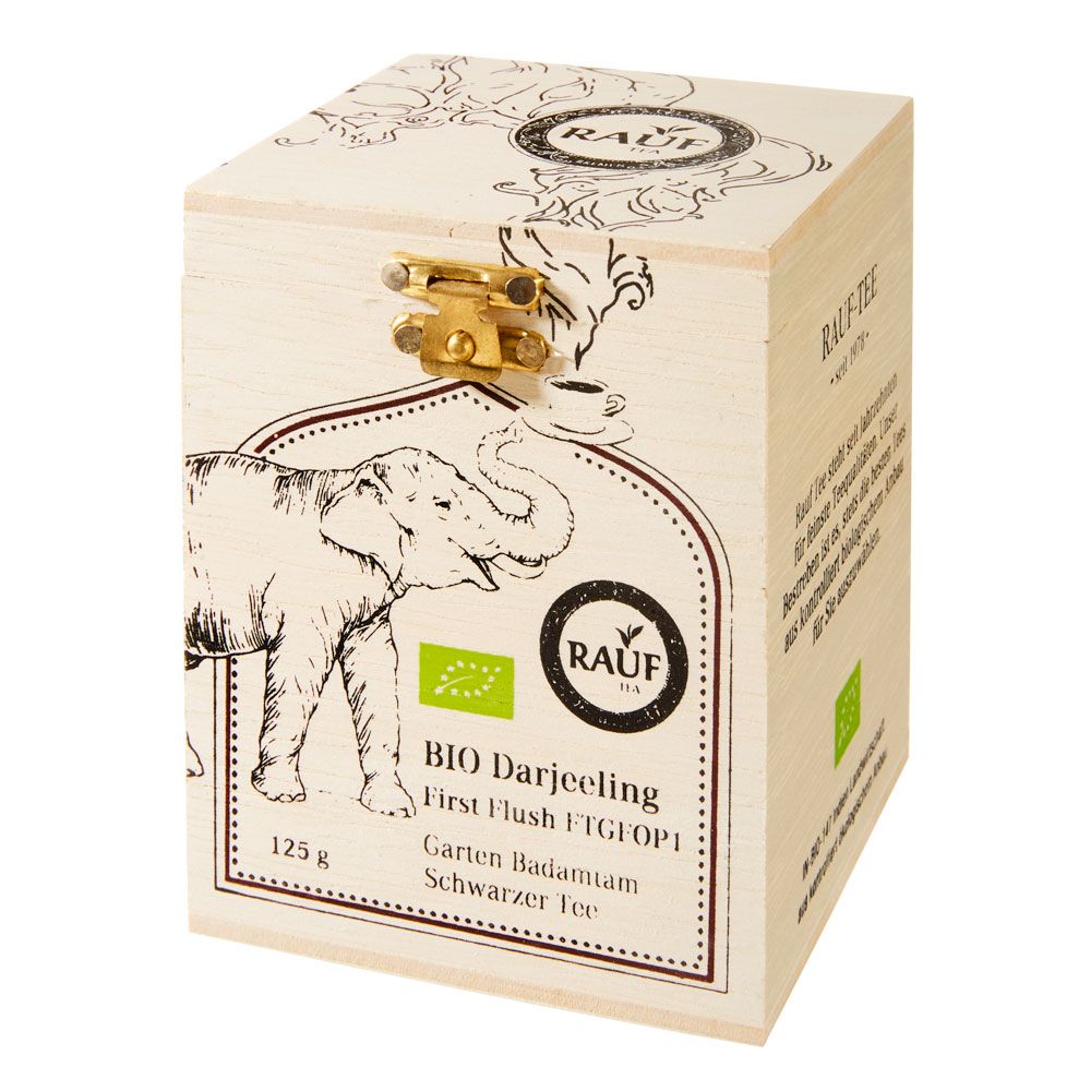 Holzkiste mit Aufdruck, goldfarbener Verschluss. Aufschrift: Rauf, Bio Darjeeling, Schwarzer Tee, 125g.
