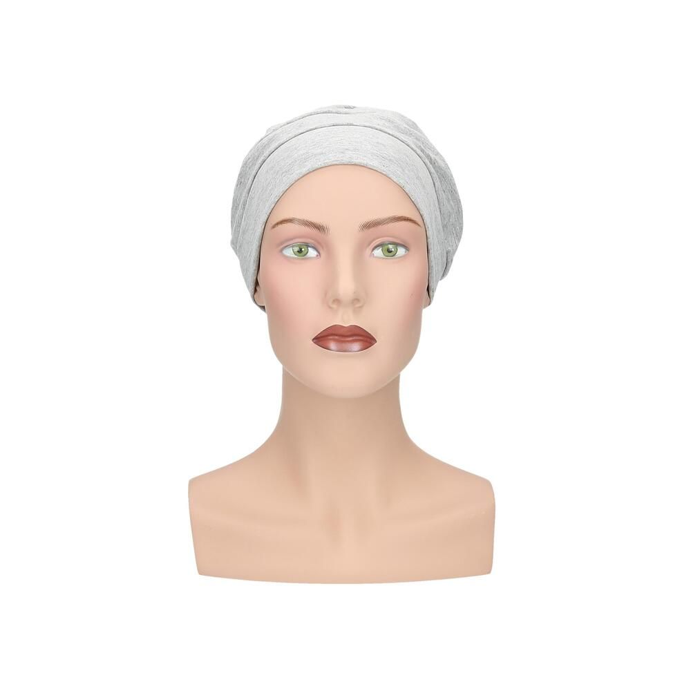 Hellgrauer Turban auf einer Schaufensterpuppe. Frontansicht. Stoffhaube mit geraffter Struktur.