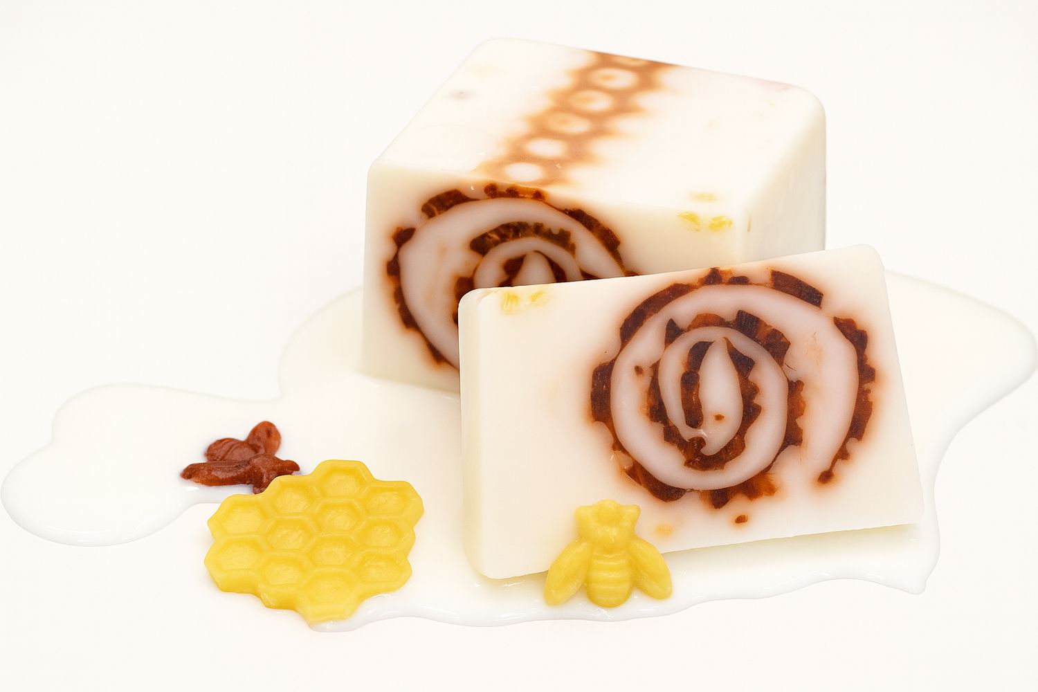 Zwei Seifenstücke mit braunem Wirbelmuster. Gelbe Bienen- und Waben-Dekoration. Flüssigkeit auf weißem Untergrund.