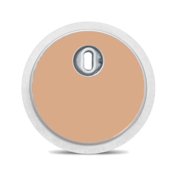Runder beiger Aufkleber mit weißem Rand und einer Öffnung in der Mitte. Für ein medizinisches Gerät.