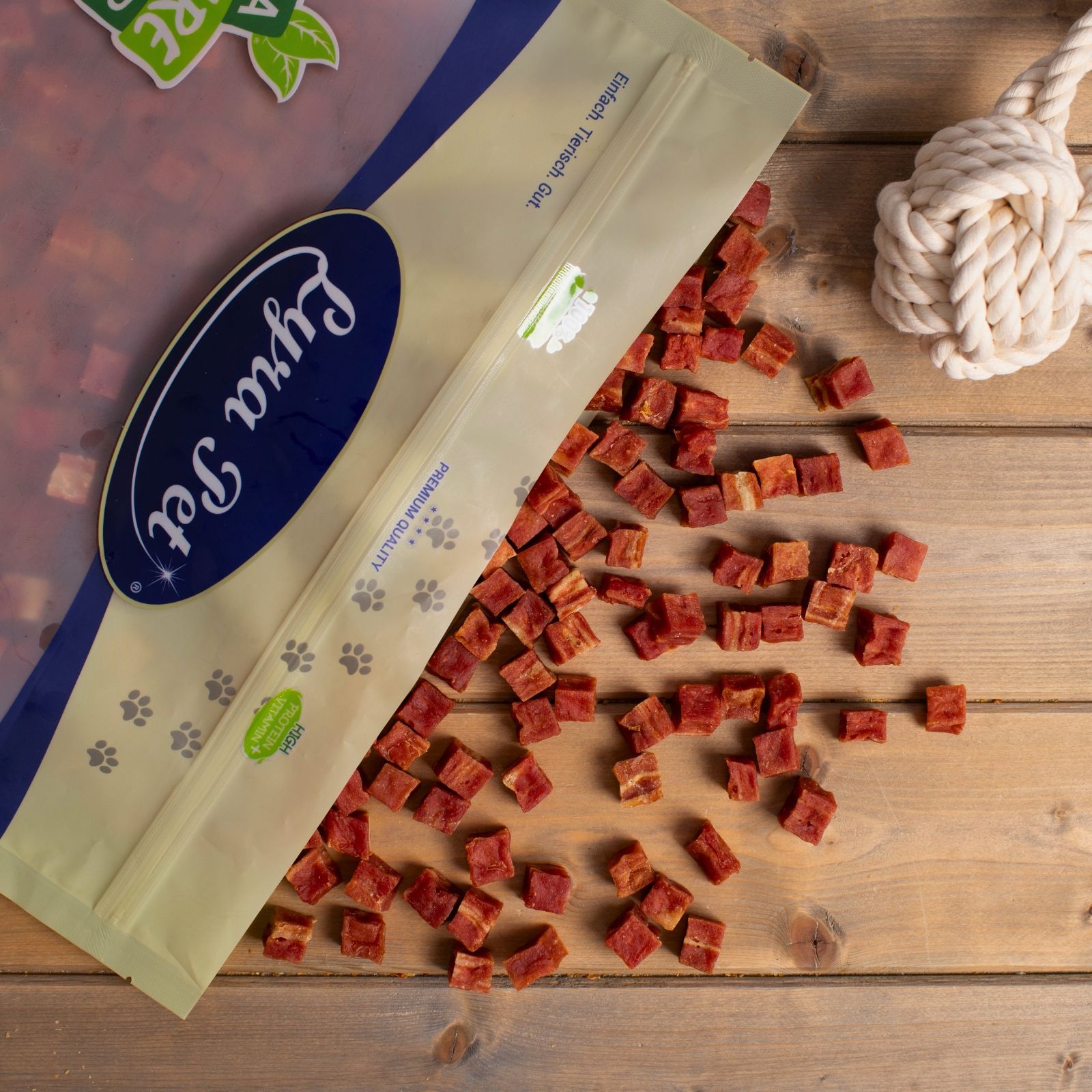 Lyra Pet® Entenfleischwürfel mit Fisch neben einer geöffneten Packung mit 'Lyra Pet' Logo.