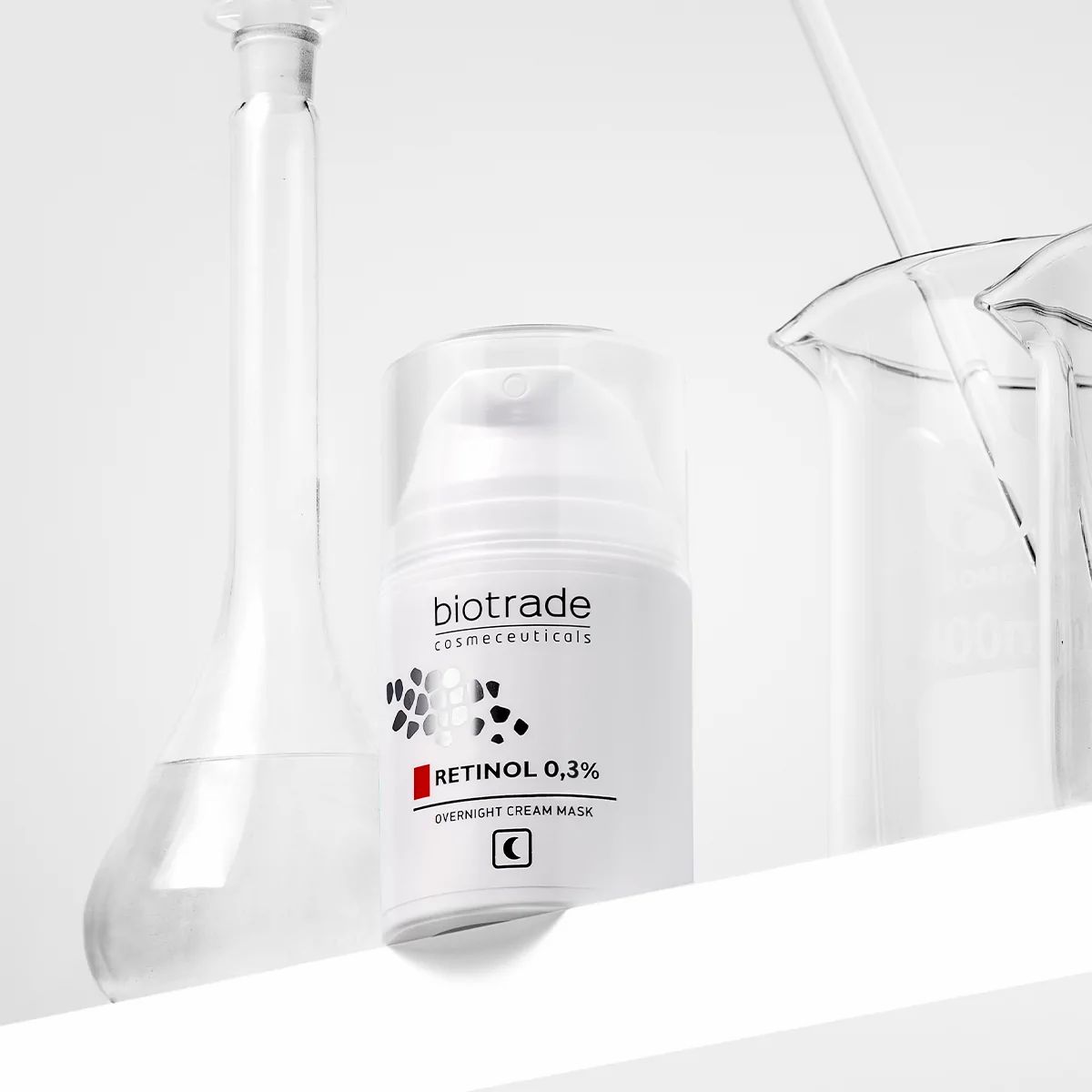 Weiße Flasche mit Aufschrift Biotrade, Retinol 0,3% und Nachtcreme-Gesichtsmaske. Neben Laborgeräten.