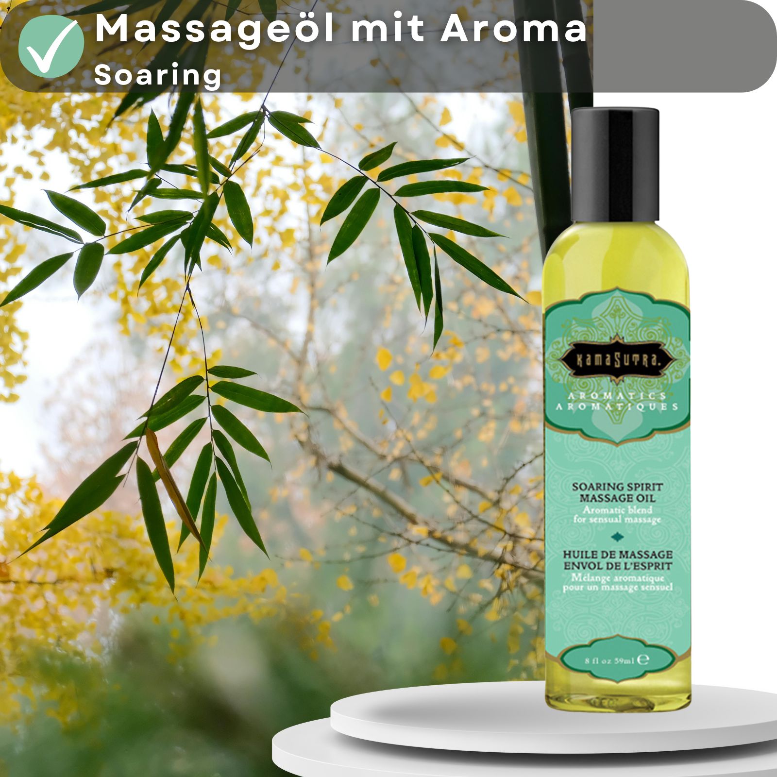 Kamasutra Massageöl mit Aroma Soaring. Flasche vor Hintergrund mit Blättern und Ästen.