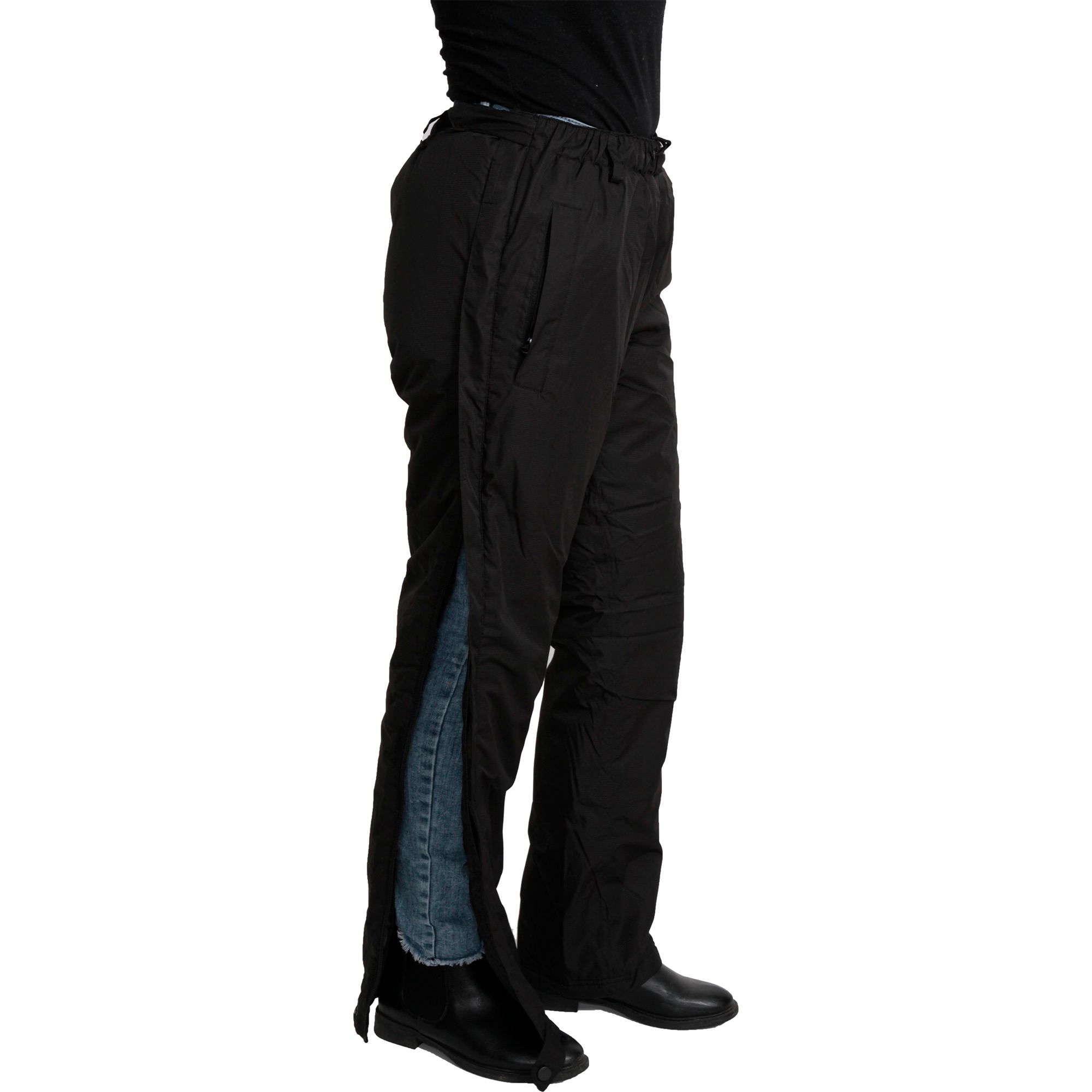 Schwarze Reha-Hose mit seitlichem Reißverschluss. Person öffnet den Reißverschluss. Innenfutter sichtbar. Schwarze Schuhe.