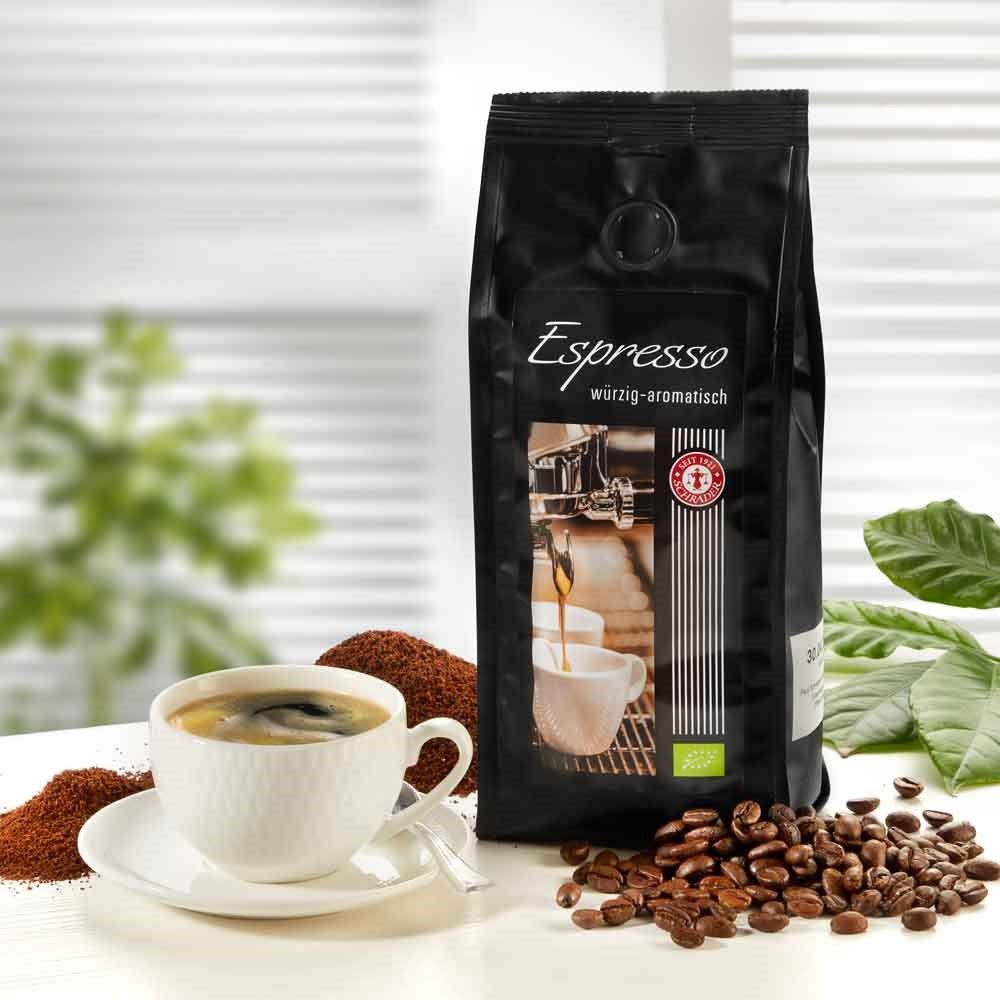 Schwarzer Beutel mit Espresso-Aufdruck, Bio-Siegel und Kaffeebohnen. Tasse Espresso daneben.