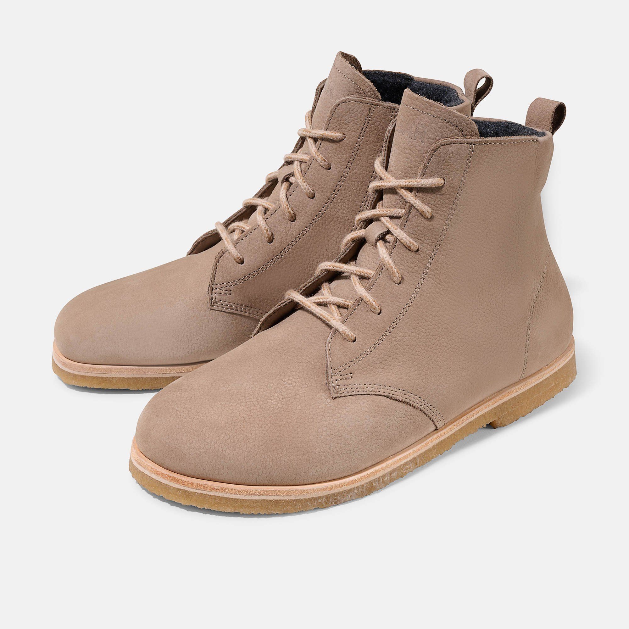 Beigefarbene Stiefeletten mit Schnürung. Hellbraune Sohle, helles Leder. Flache Form, breite Passform.