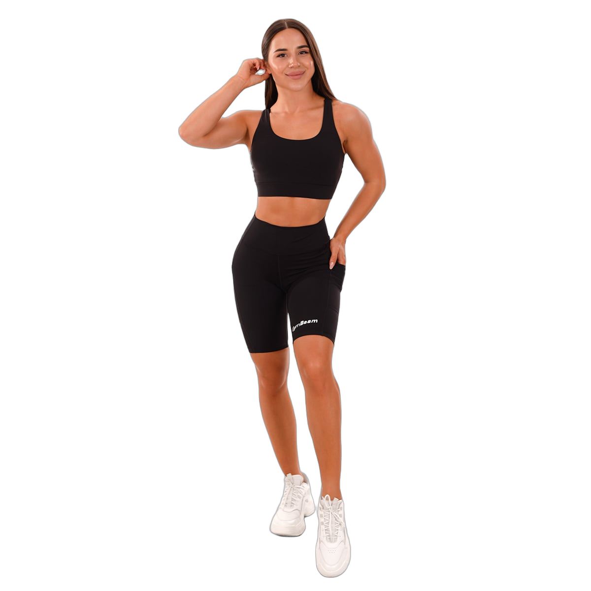 Frau in schwarzen Biker-Shorts mit hoher Taille und seitlichen Taschen.