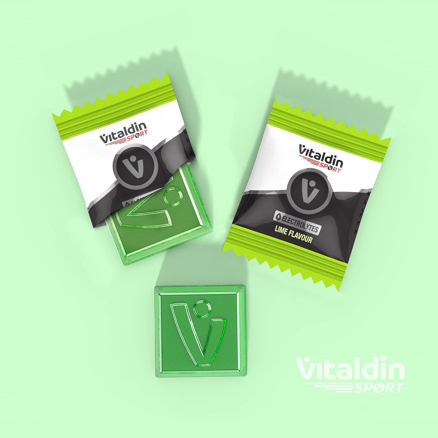 Drei grüne Gummibärchen und zwei kleine Päckchen. Aufschrift: VITALDIN SPORT, Electrolytes, Lime Flavour.